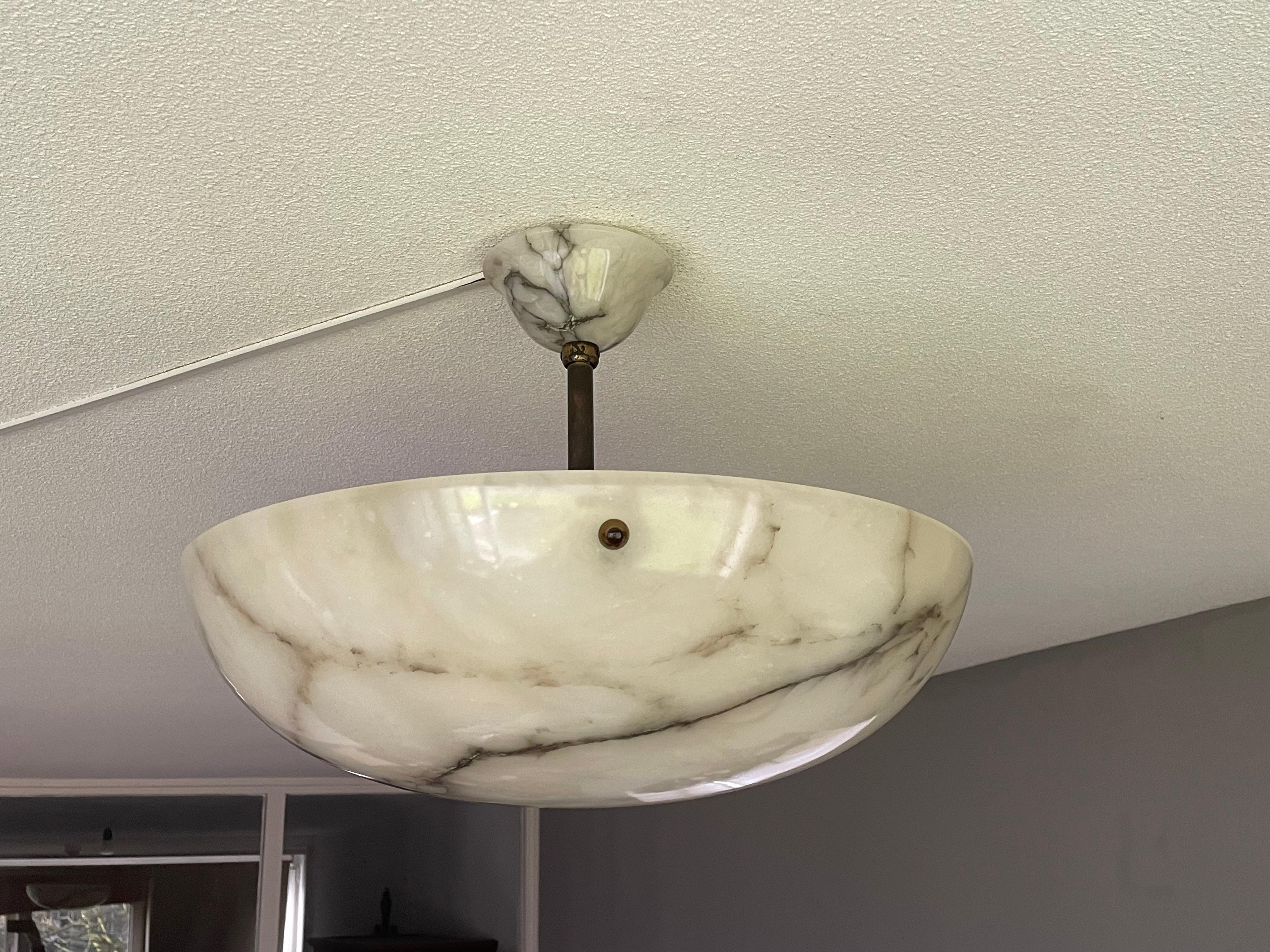 Stunning marble-like flush mount with a great size alabaster mineral stone shade.

Thanks to its large size, its deep bowl shape and its timeless design this three light alabaster flush mount is bound to light up both your days and evenings. It is