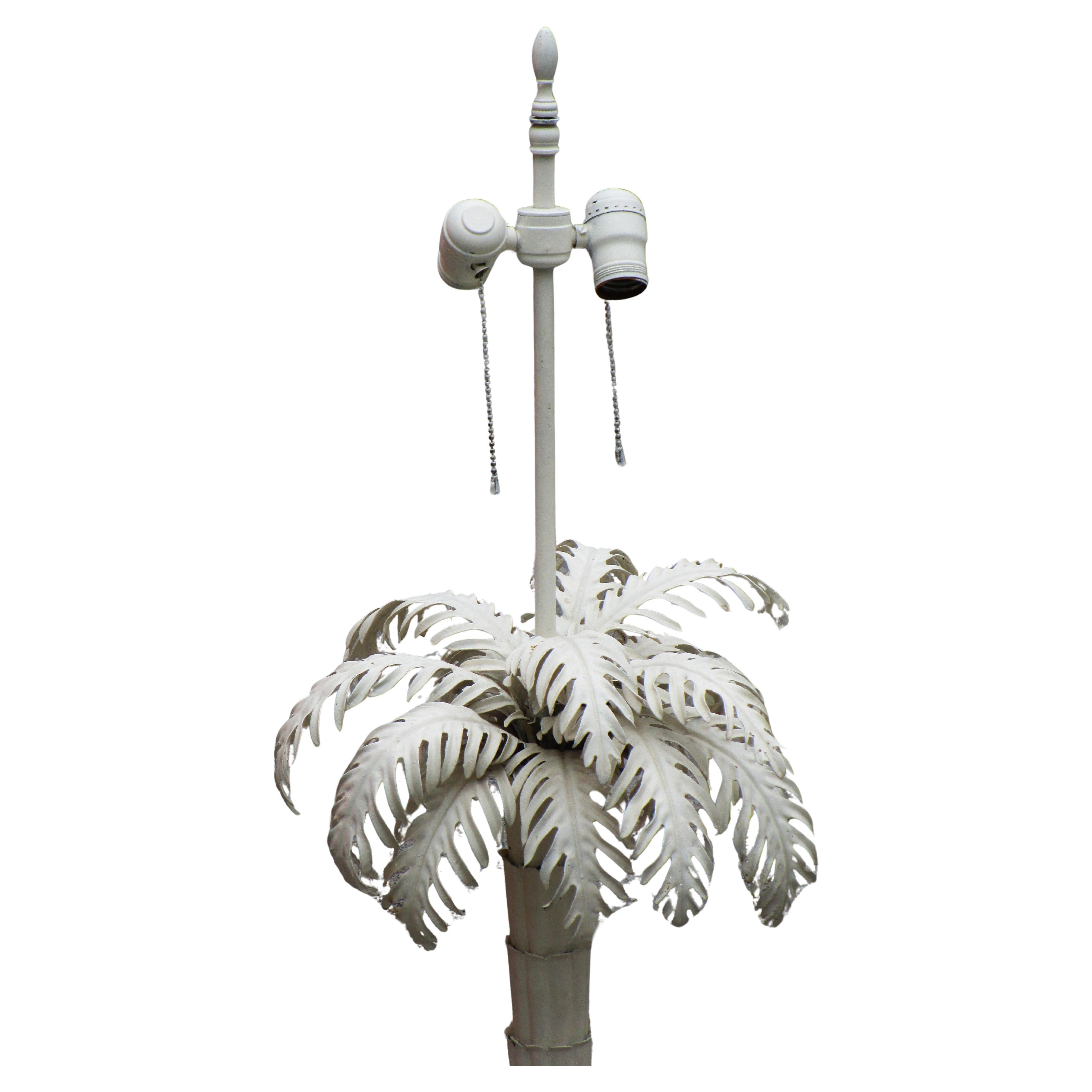 Large tin tole palm tree table lamp in older soft white painted surface. Beautifully detailed metalwork. Double electric sockets w/ pull chains / electric cord w/ on off switch. Measures 39