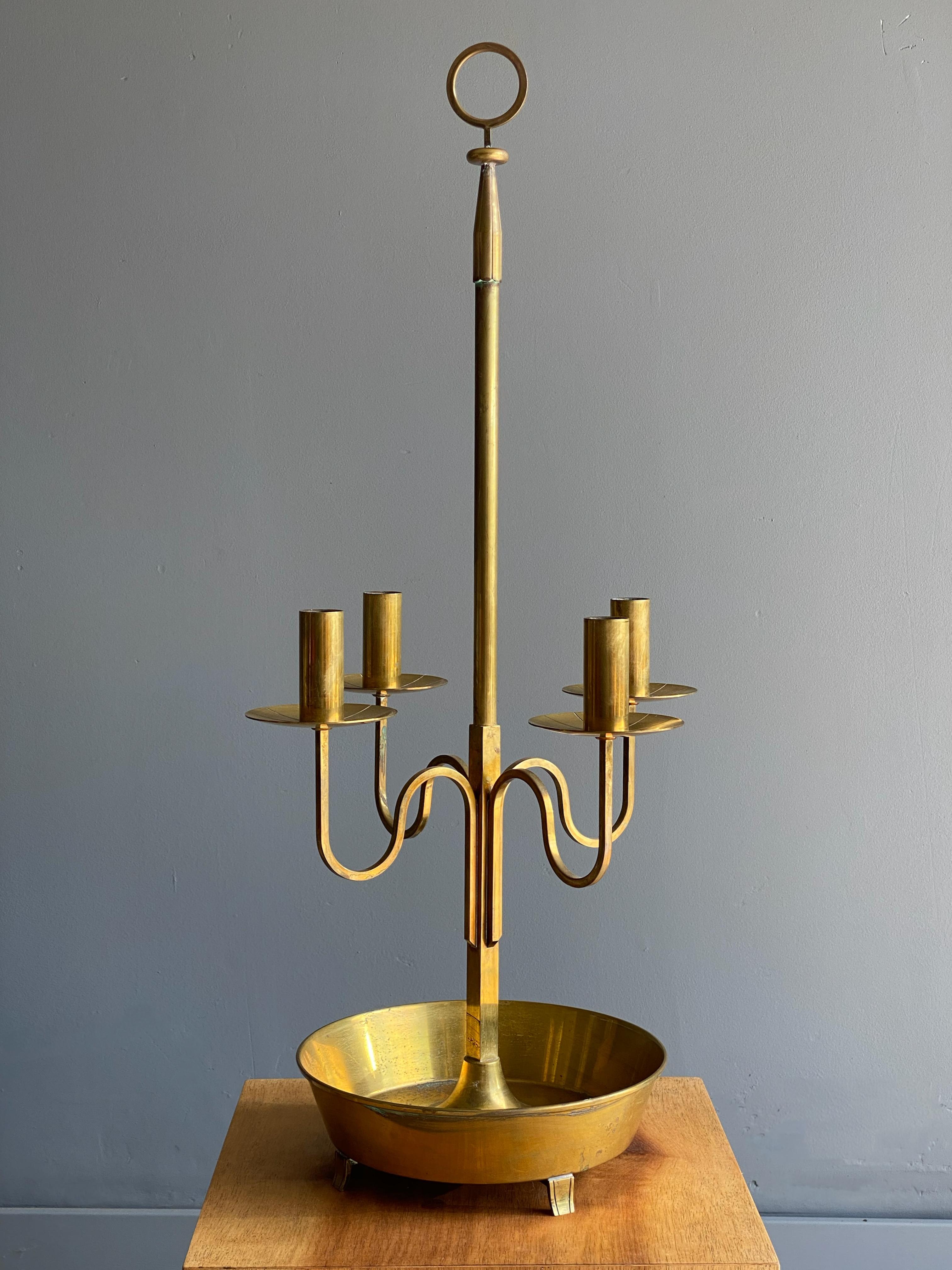 Gorgeous solid brass candelabra designed by Tommi Parzinger for Dorlyn Silversmiths, circa 1950s. One of the larger candelabras for Dorlyn, this example speaks for itself. We have decided to keep the patina as we believe it is more attractive this