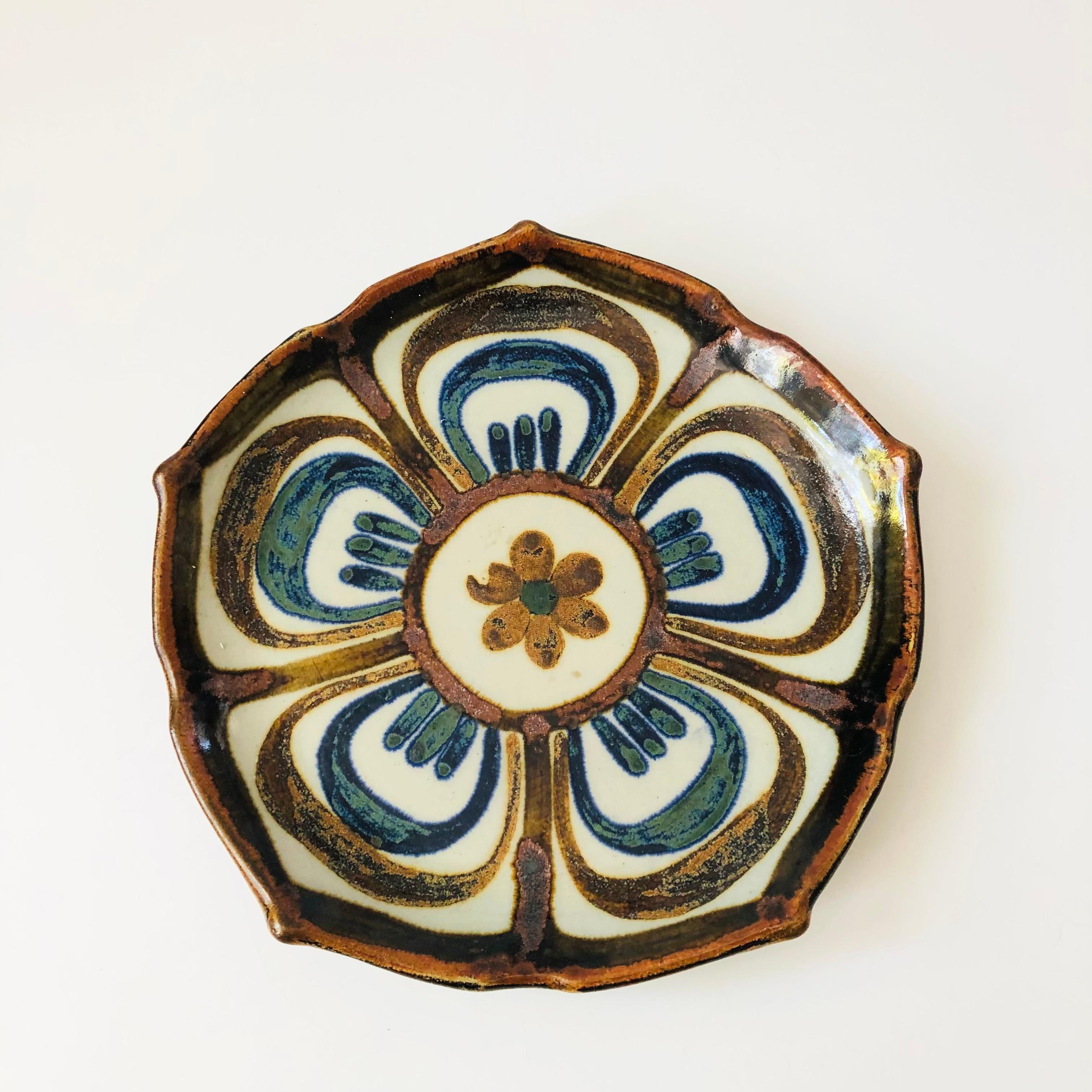 A large Tonala el Palomar Mexican folk art pottery plate in the lotus design by Ken Edwards. Beautiful handpainted accents in blue and brown glazes. Marked on the base. Nice size for using as a serving or decorative tray.

