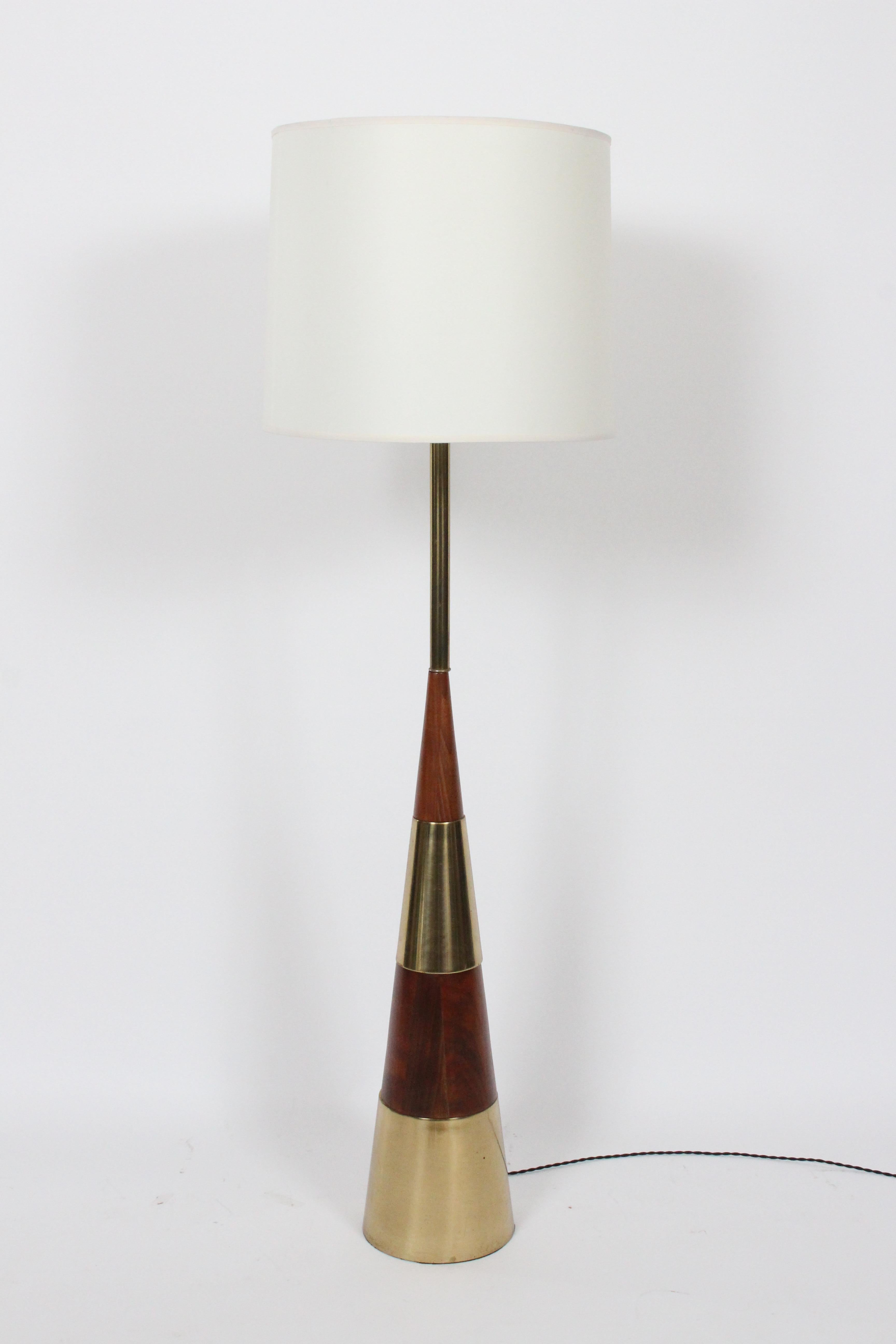Tony Paul for Westwood Industries solid walnut and brass stacked cone floor lamp, 1950s.  Featuring a balanced layered and reflective conical bright brass and solid Walnut form with plated tubular stem. Small footprint. Shade shown for display only