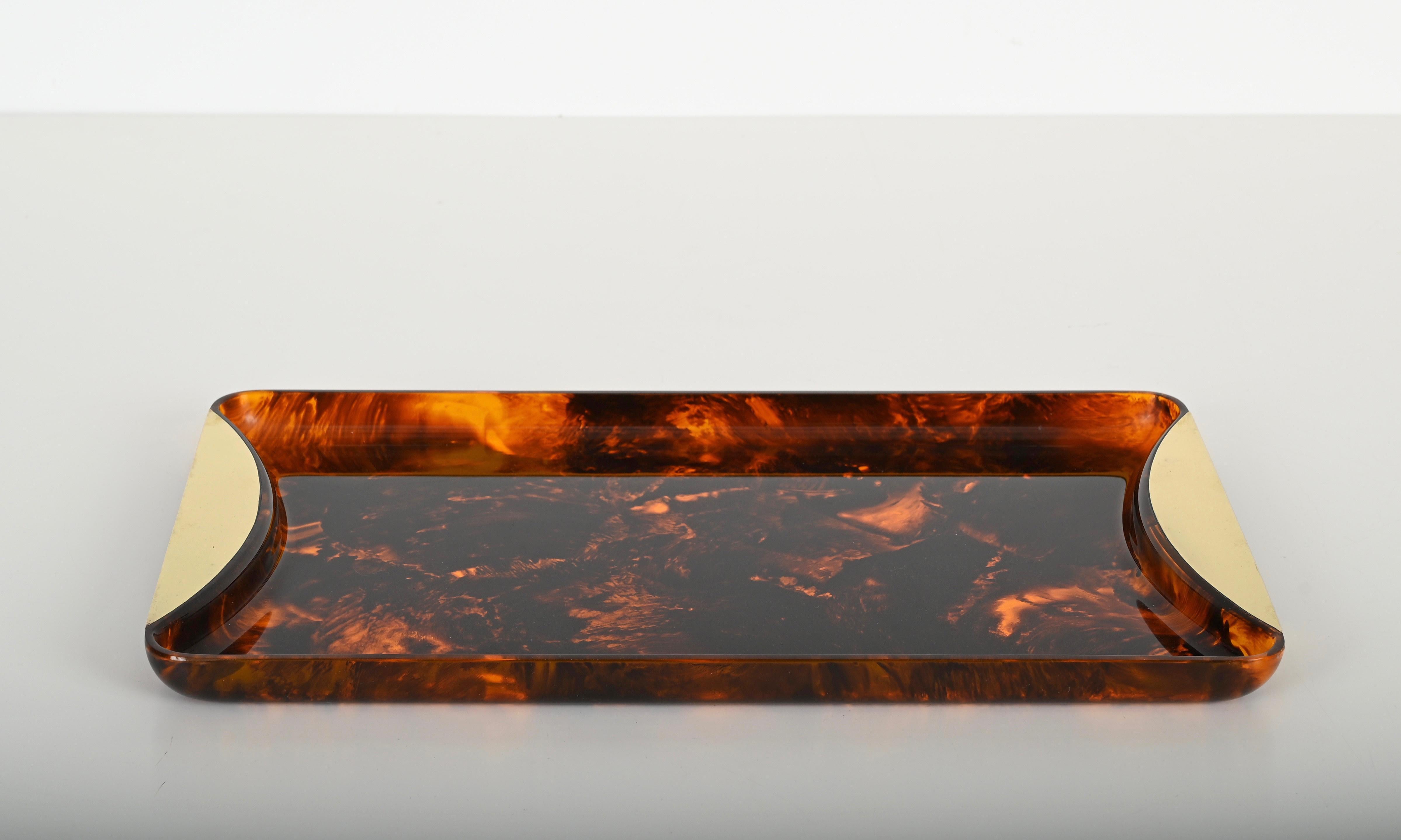 Mid-century tray in a gorgeous tortoiseshell effect lucite and brass. This charming rectangular tray, clearly in the style of Christian Dior, was produced in Italy during the 1970s by Guzzini.

In fabulous condition, the elegant brass handles pair
