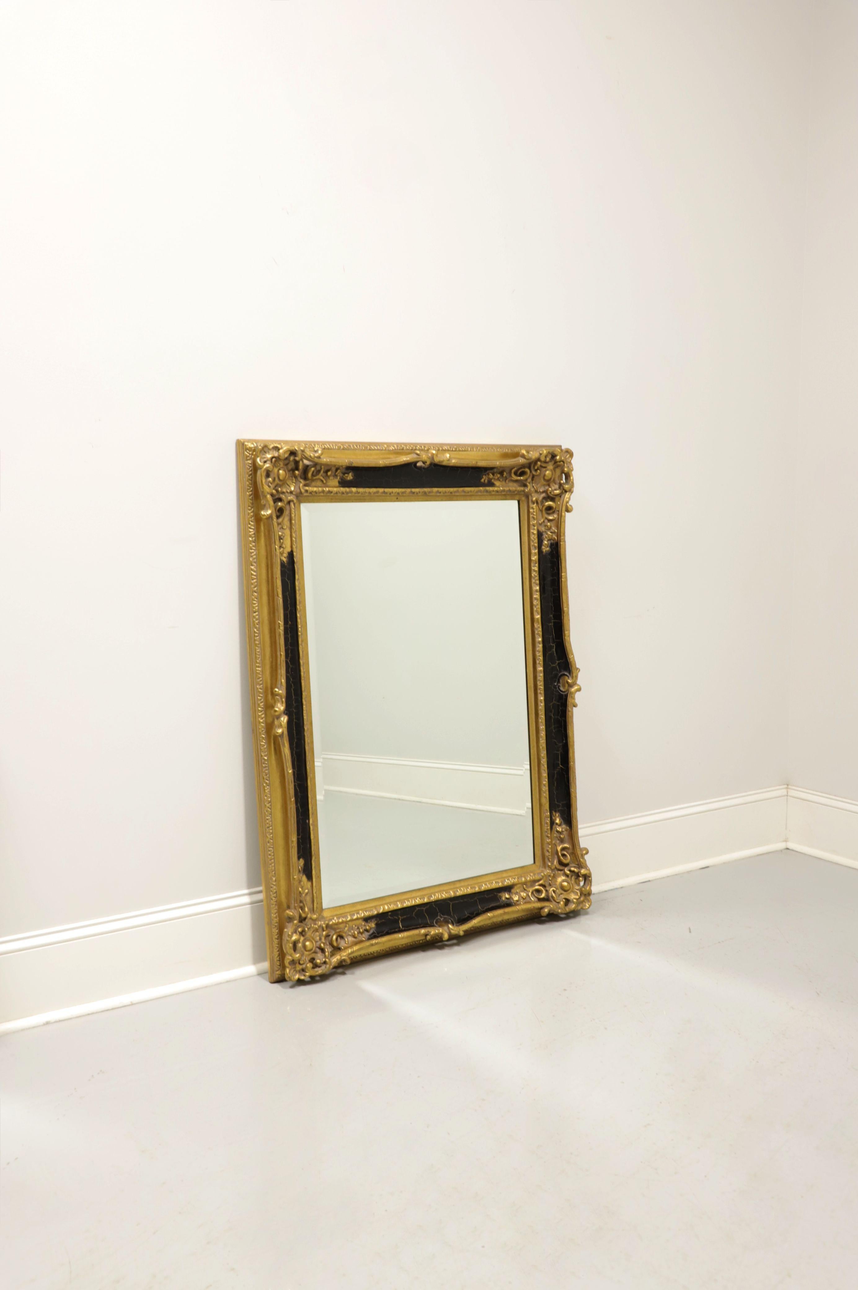 A Traditional style wall mirror, unbranded. Beveled edge mirror glass in an ornately carved wood frame with a crackle finish of gold gilt and black. Made in the USA, in the late 20th Century.

Measures: 34.5W 3.5D 46.25H, Weighs 30lbs

Exceptionally