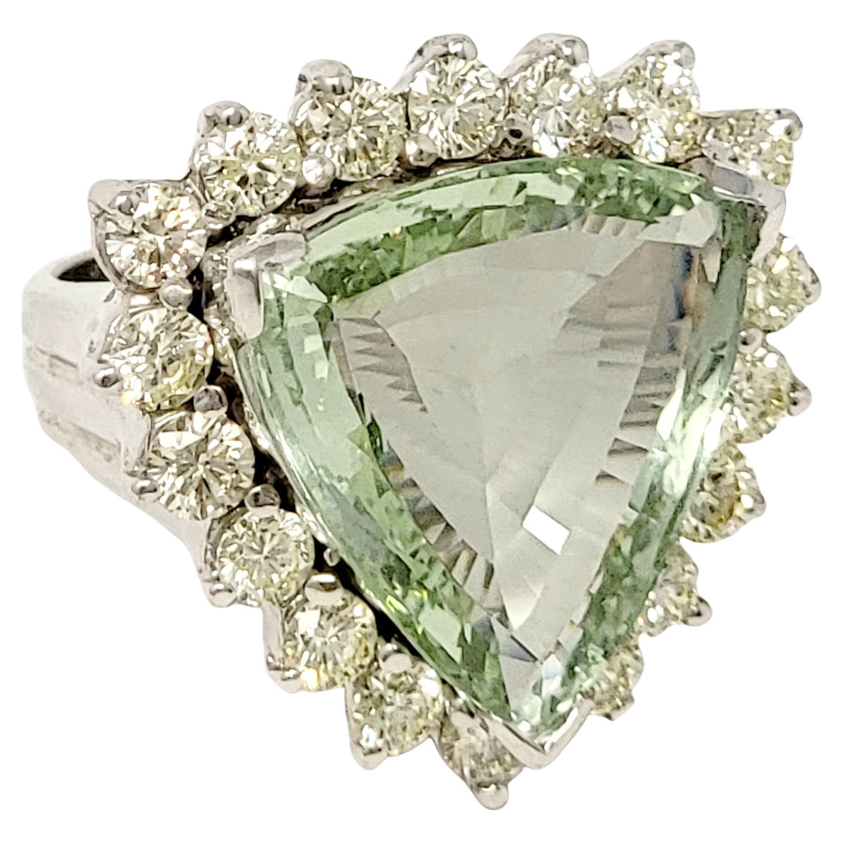 Ring size: 6.5

Stunningly sparkly, massive green beryl and diamond cocktail ring. This eye-catching piece makes a bold statement with both its impressive size and unique color. The beautiful triangular cut beryl stone is a crystal clear light