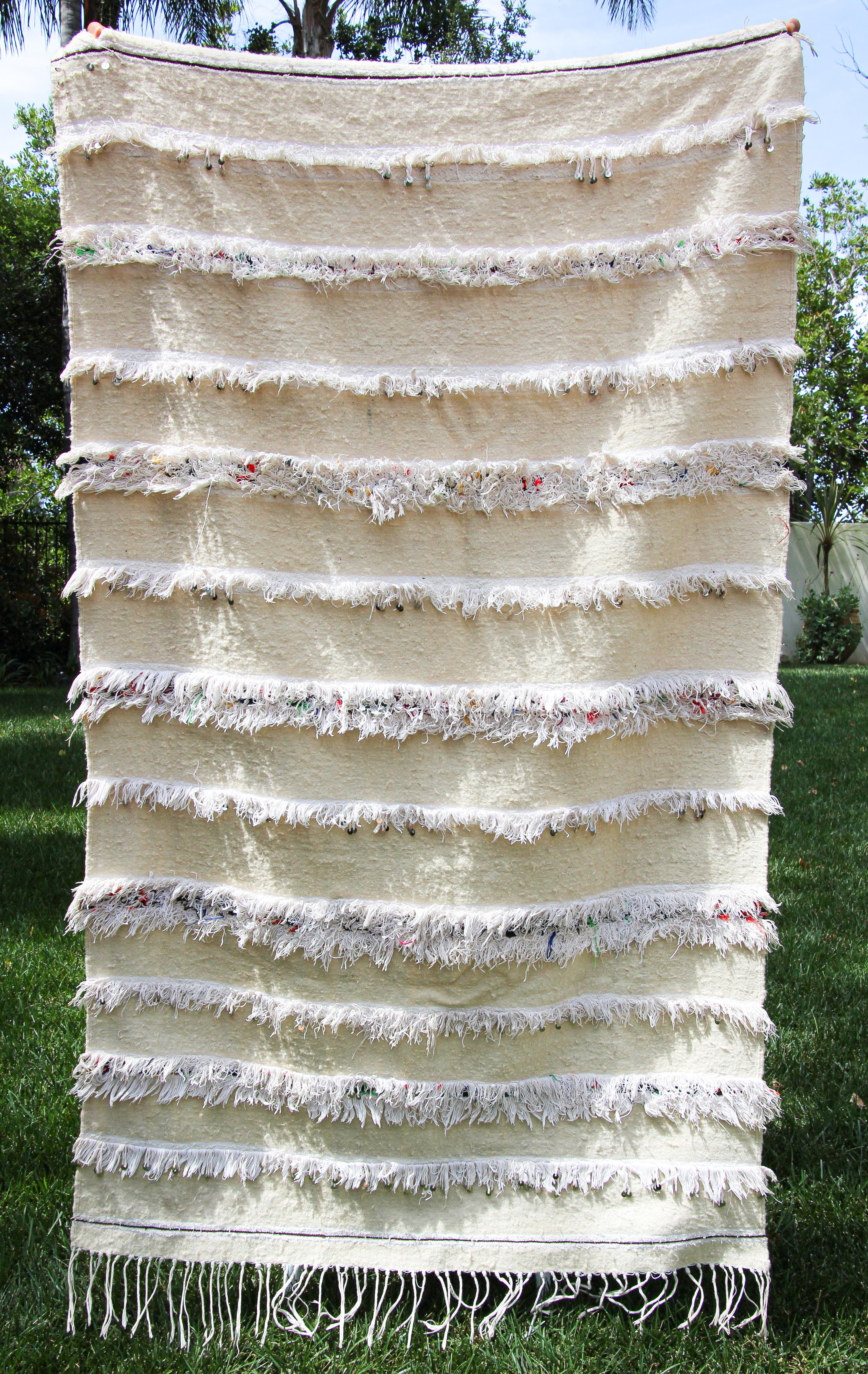 Die Zaiane Stammes-Schals enthalten Mengen von Pailletten in ihrem Design, um eine beeindruckende dekorative Wirkung auf die abwechselnden Streifen von wo und Baumwollgarn zu erreichen.Diese Berber handgewebten Schals werden von den Frauen der Beni