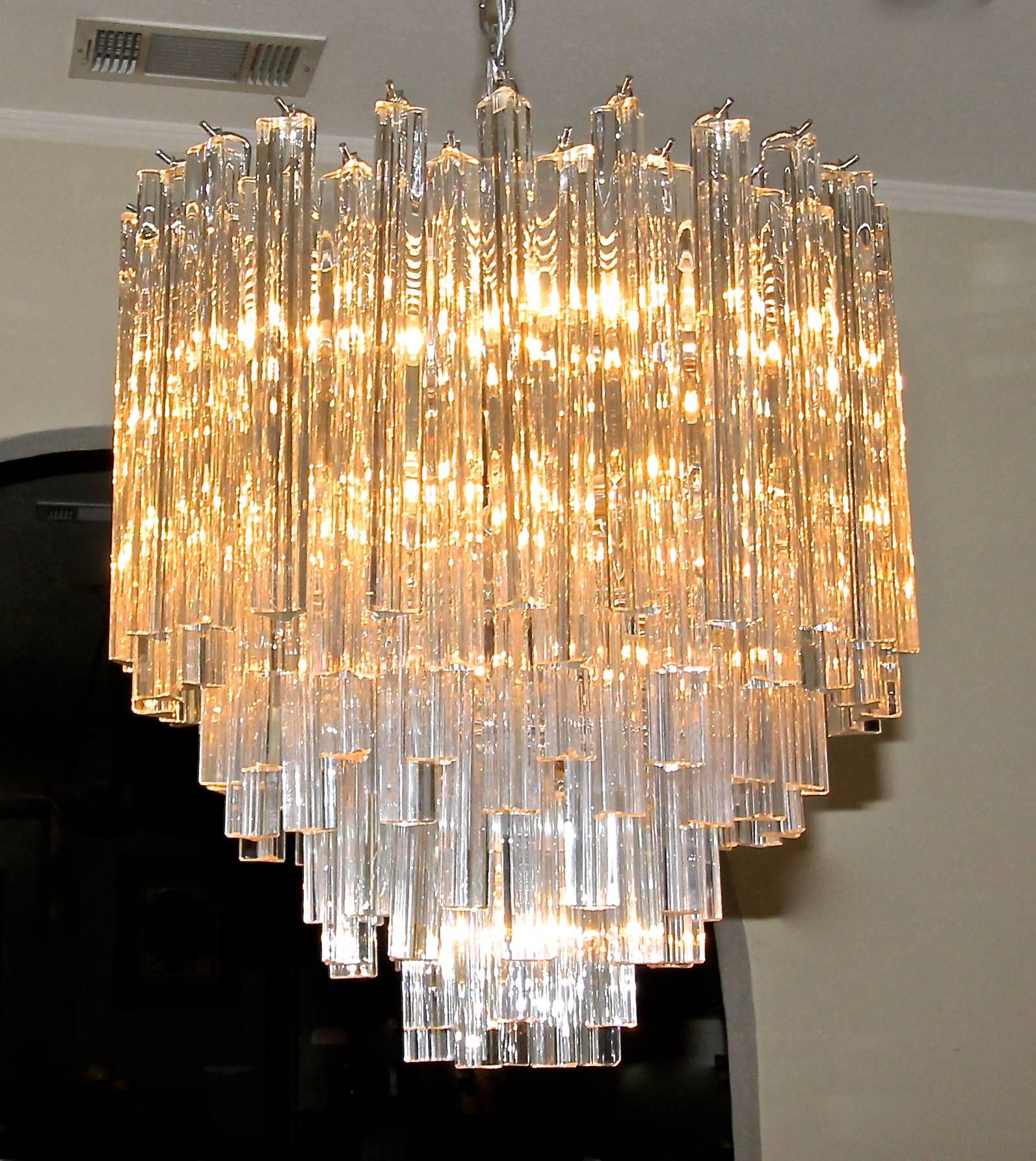 Gran araña redonda treidi o triedri con capas de prismas de cristal de tres caras y estructura de acero cromado. Gran diseño vintage italiano de Murano a la manera de Venini. Recién cableado para EE.UU., el aparato utiliza 19 luces en total, 18
