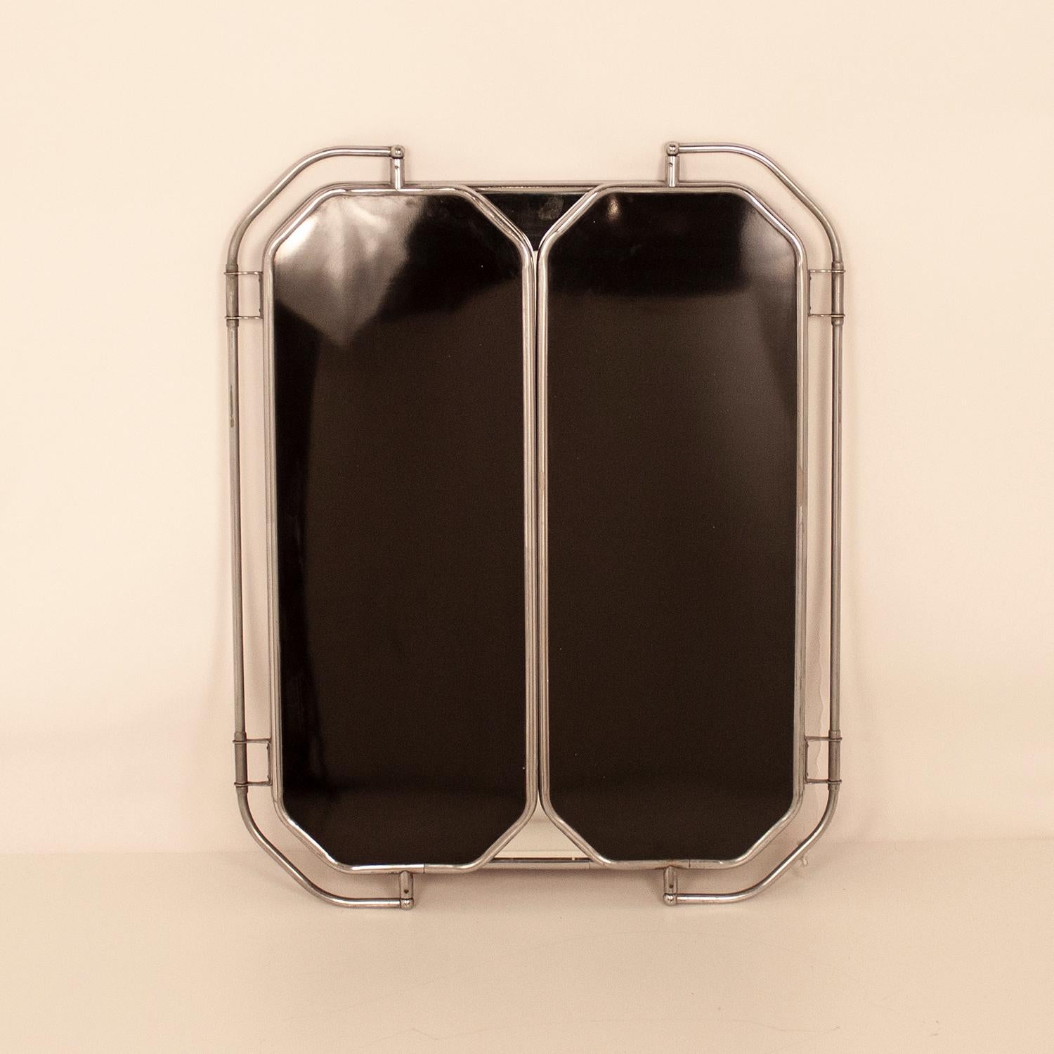Large triptych mirror Bakelite and chrome. Spain, 1940s.
It consists of the central mirror and two oscillating side mirrors. On the side mirrors, the back is made of black Bakelite.
Measures fully open:
Width 45.66in (116cm.)
Depth 0.78in