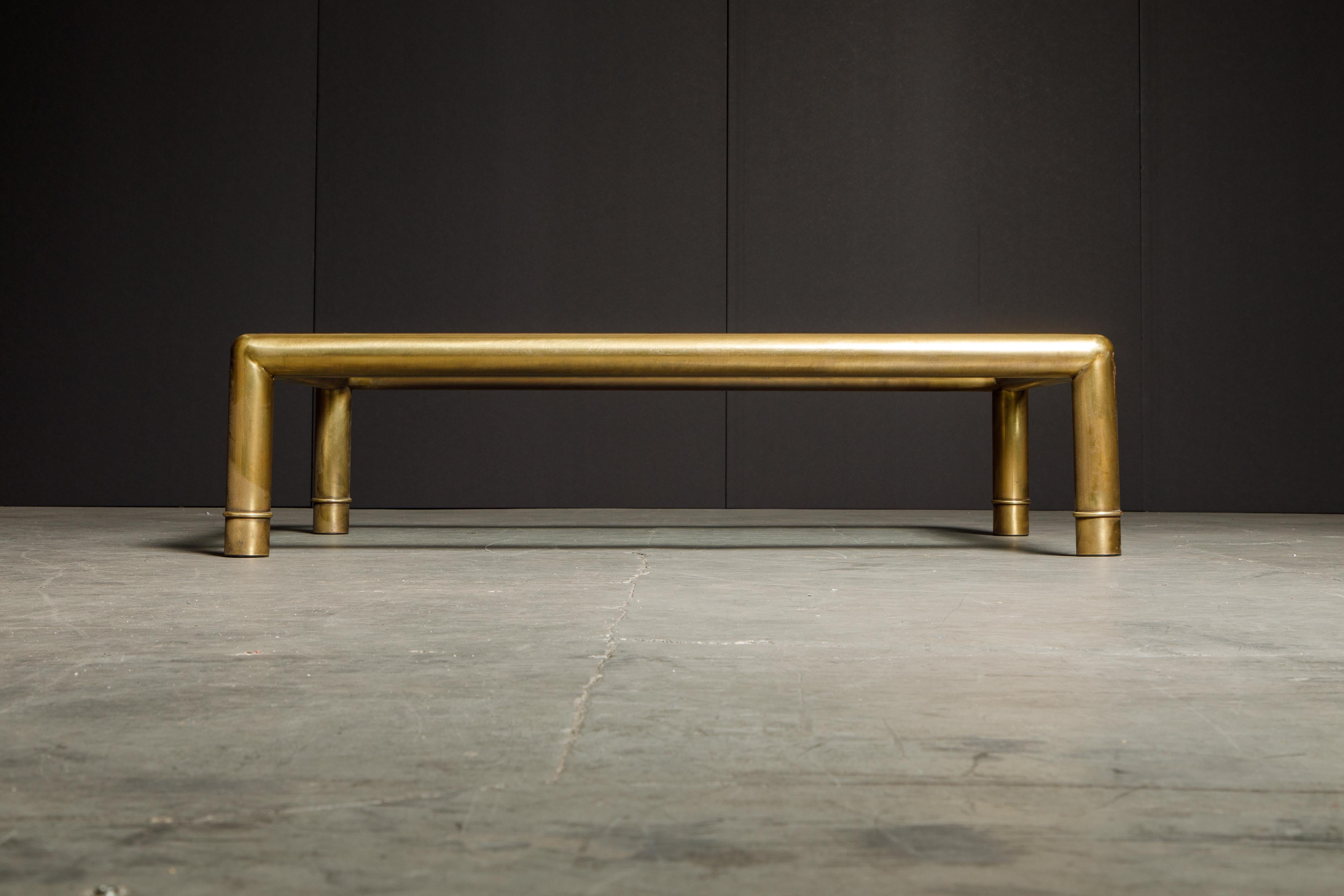 This stunning coffee table by Mastercraft features a generously large size and gorgeous tubular brass frame with a large bevelled edge clear glass top. The four legs have a band on each leg mimicking bamboo in a subtle way and making this cocktail