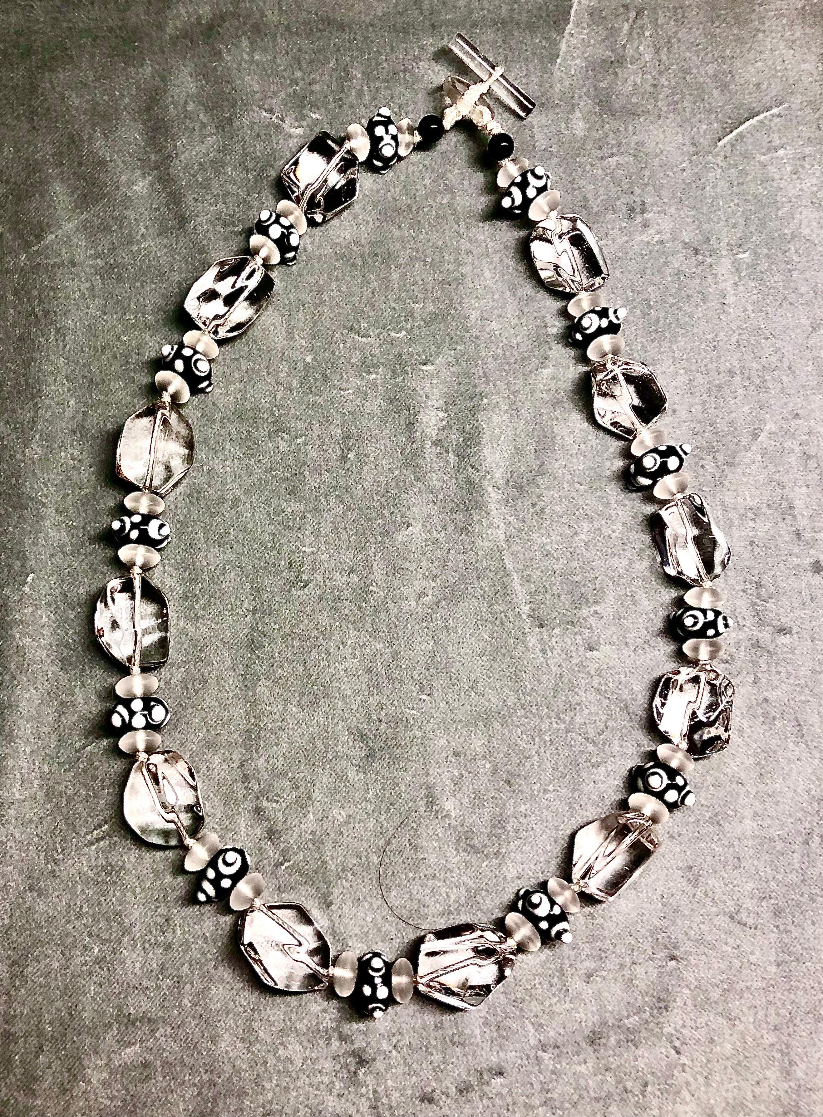 Fabulously elegant yet understated necklace of very large tumbled chunky rock crystal beads. In between the shimmering rock crystal “rocks“ are Art Deco black and white Venetian lamp work beads. These beads are of exquisite quality and most unusual