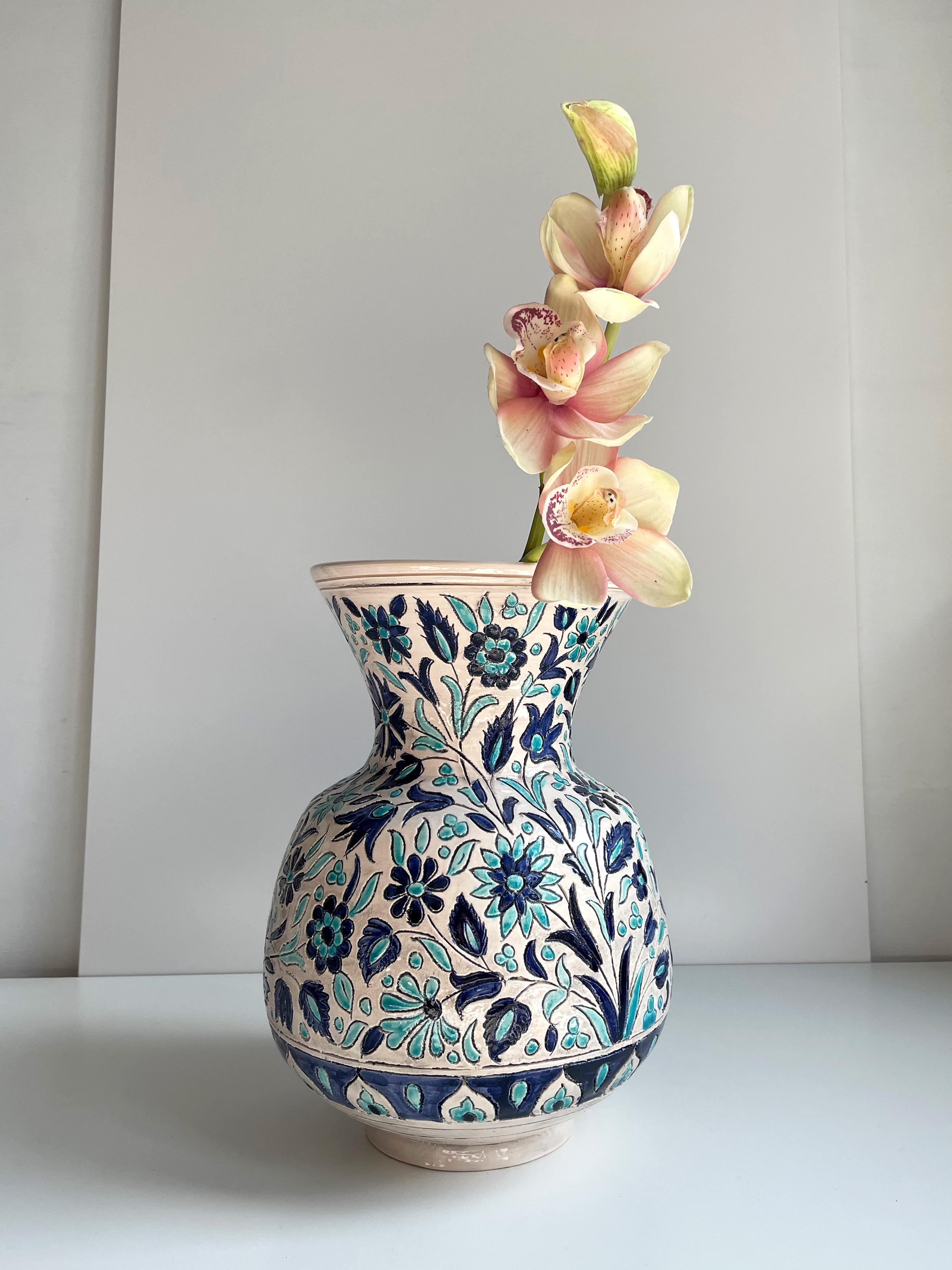 Large handmade vintage Turkish floor vase. Hand-carved stylized floral incisions filled with light and dark blue glaze on the warm white base creating an abundance of different types of flowers and decorations. Signed under base. Beautiful vintage