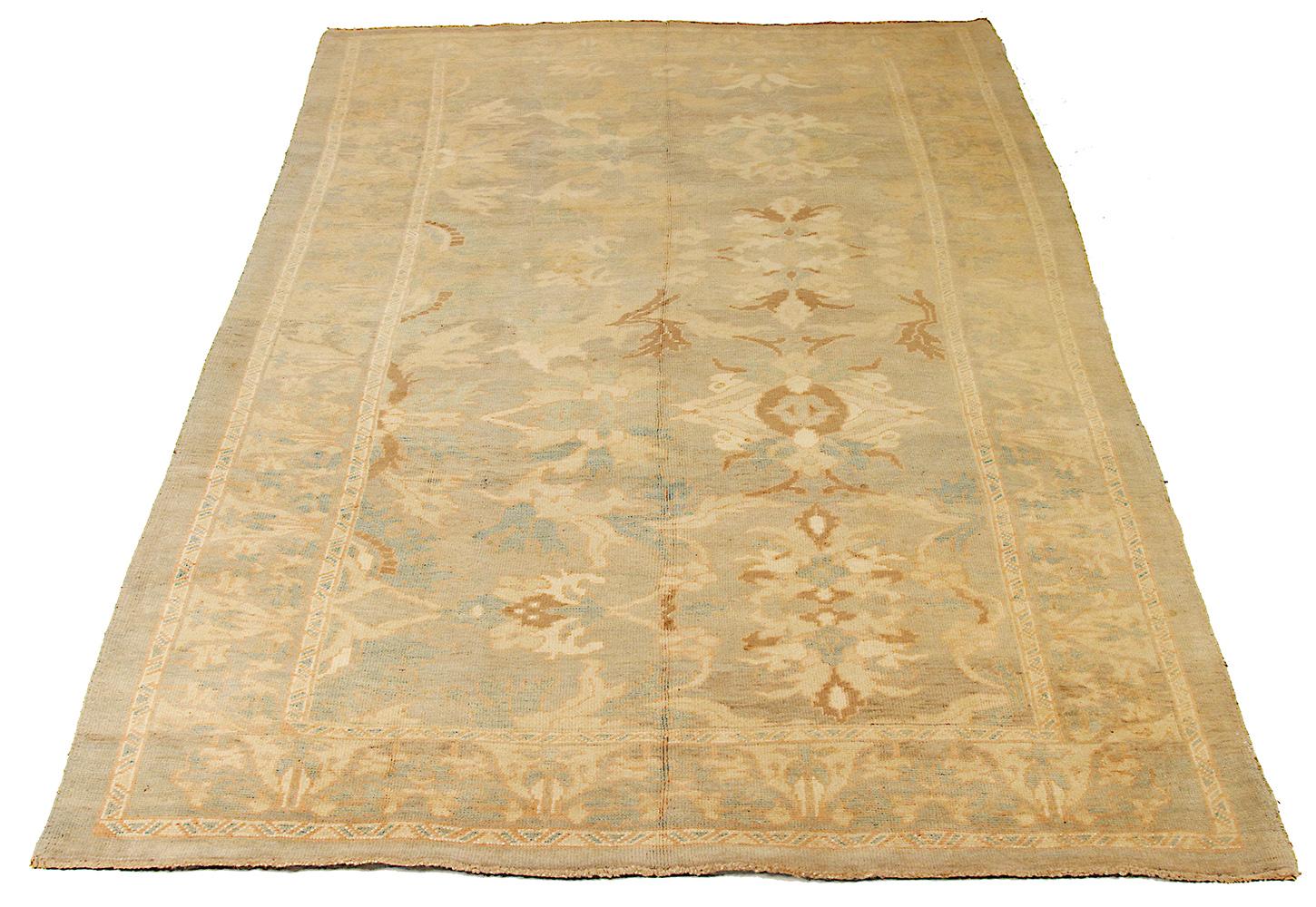Large handmade Turkish area rug from high-quality sheep’s wool and colored with eco-friendly vegetable dyes that are proven safe for humans and pets alike. It’s a Donegal design showcasing a faded beige field with brown, ivory and blue floral