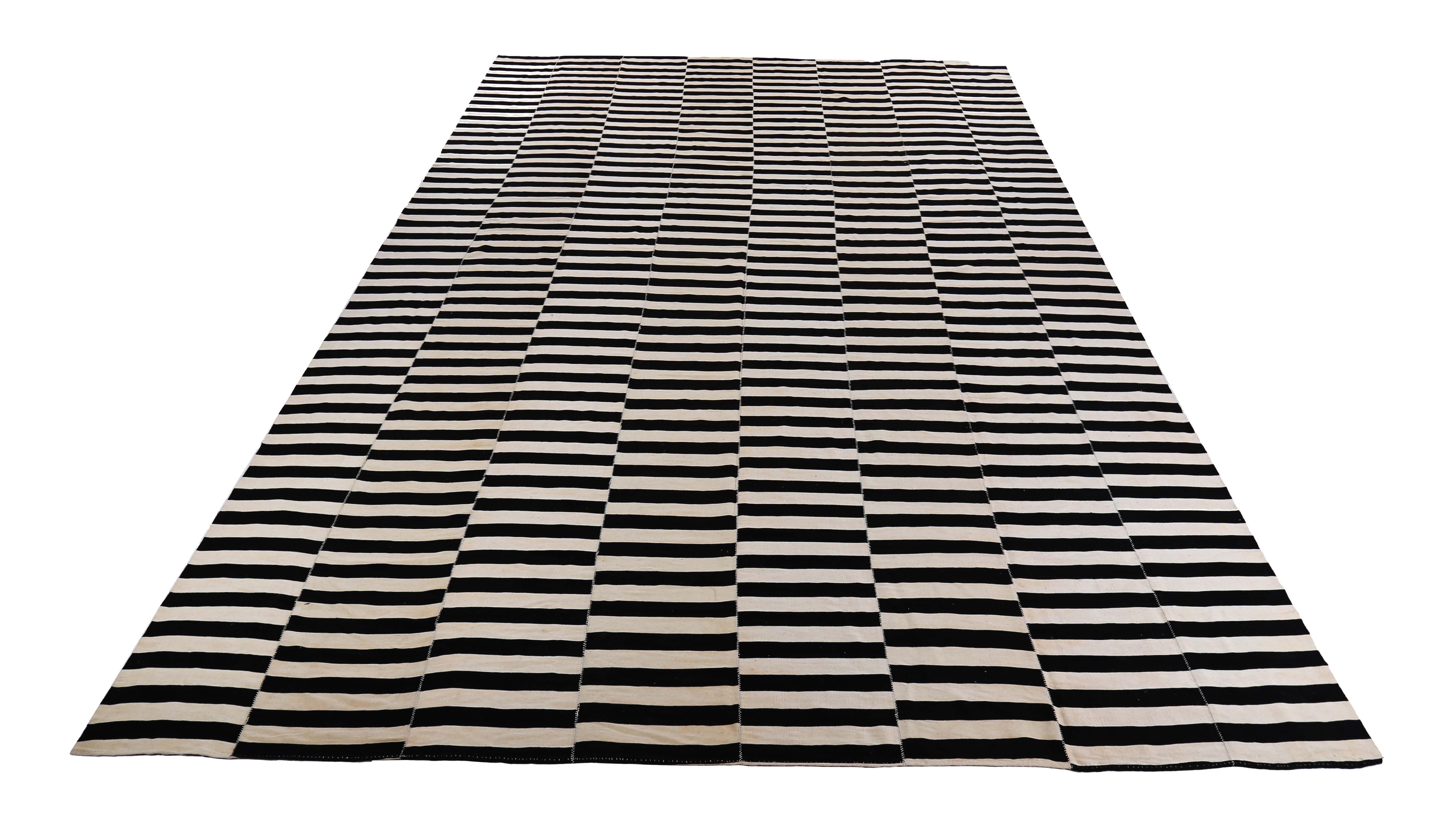 Esta exquisita alfombra turca está tejida a mano con la mejor lana de oveja, lo que la convierte en un complemento ideal para cualquier espacio moderno, contemporáneo o rústico. El diseño de tejido plano Kilim muestra rayas negras sobre un campo