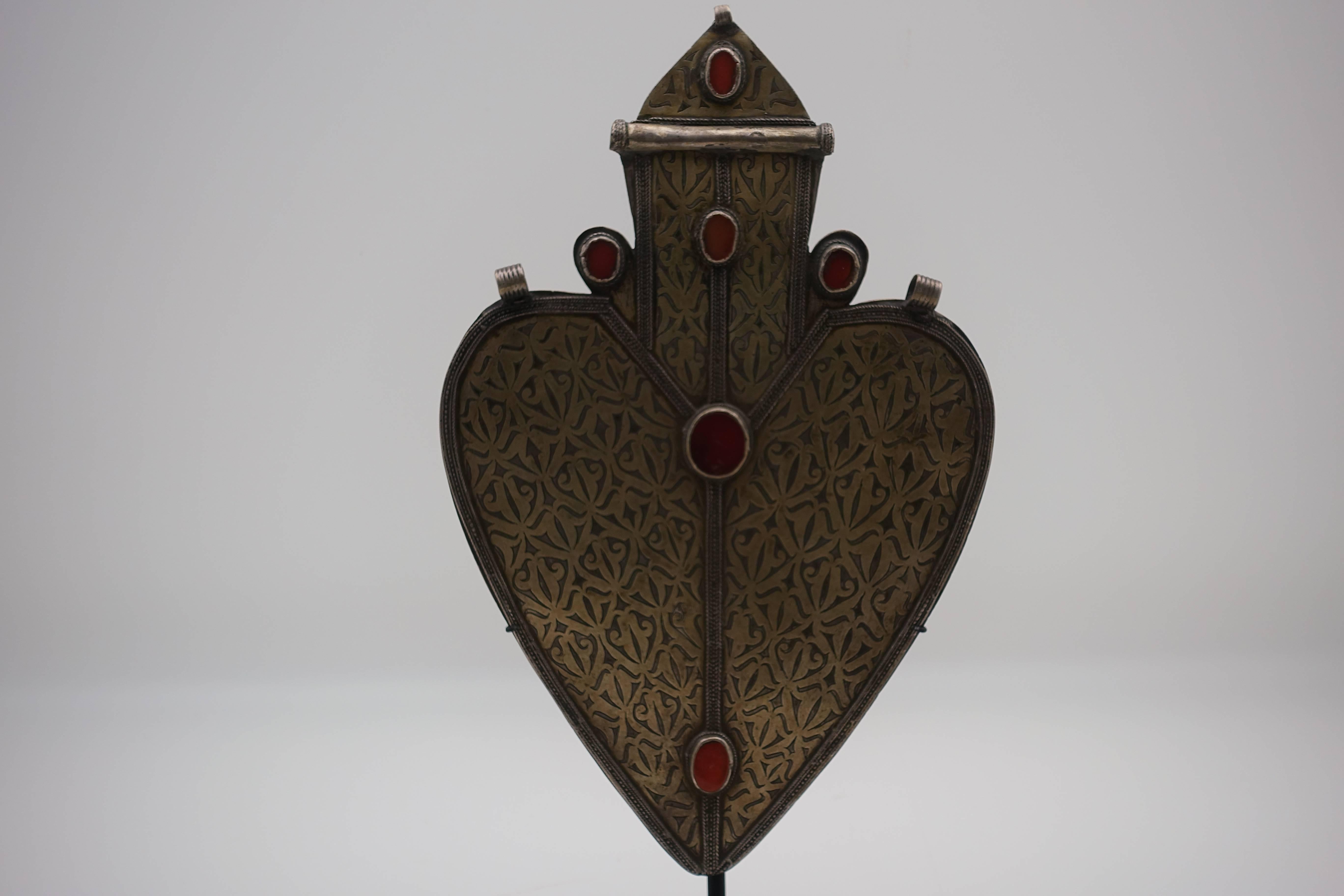 Large coin-silver Turkmen heart shaped pendant from Turkmenistan, boarding Afghanistan. Antique silver pendant from the early 1900s. Hand-tooled coin silver with six carnelian settings, mounted on a custom, black painted metal base.