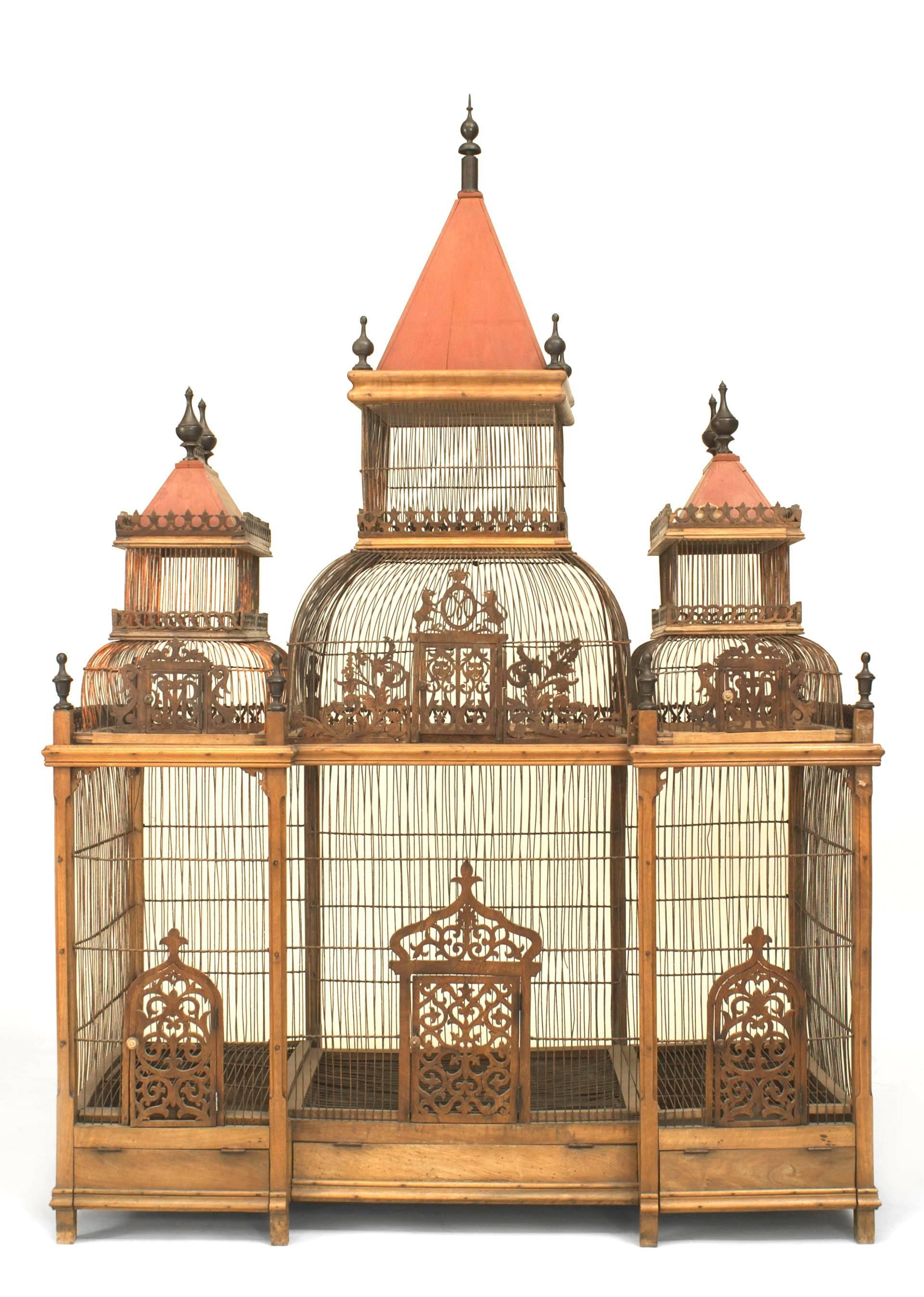 French Victorian style (19/20th Cent) walnut large birdcage with 3 red dome tops having ebonized finials and trimmed with filigree tracery carving.
