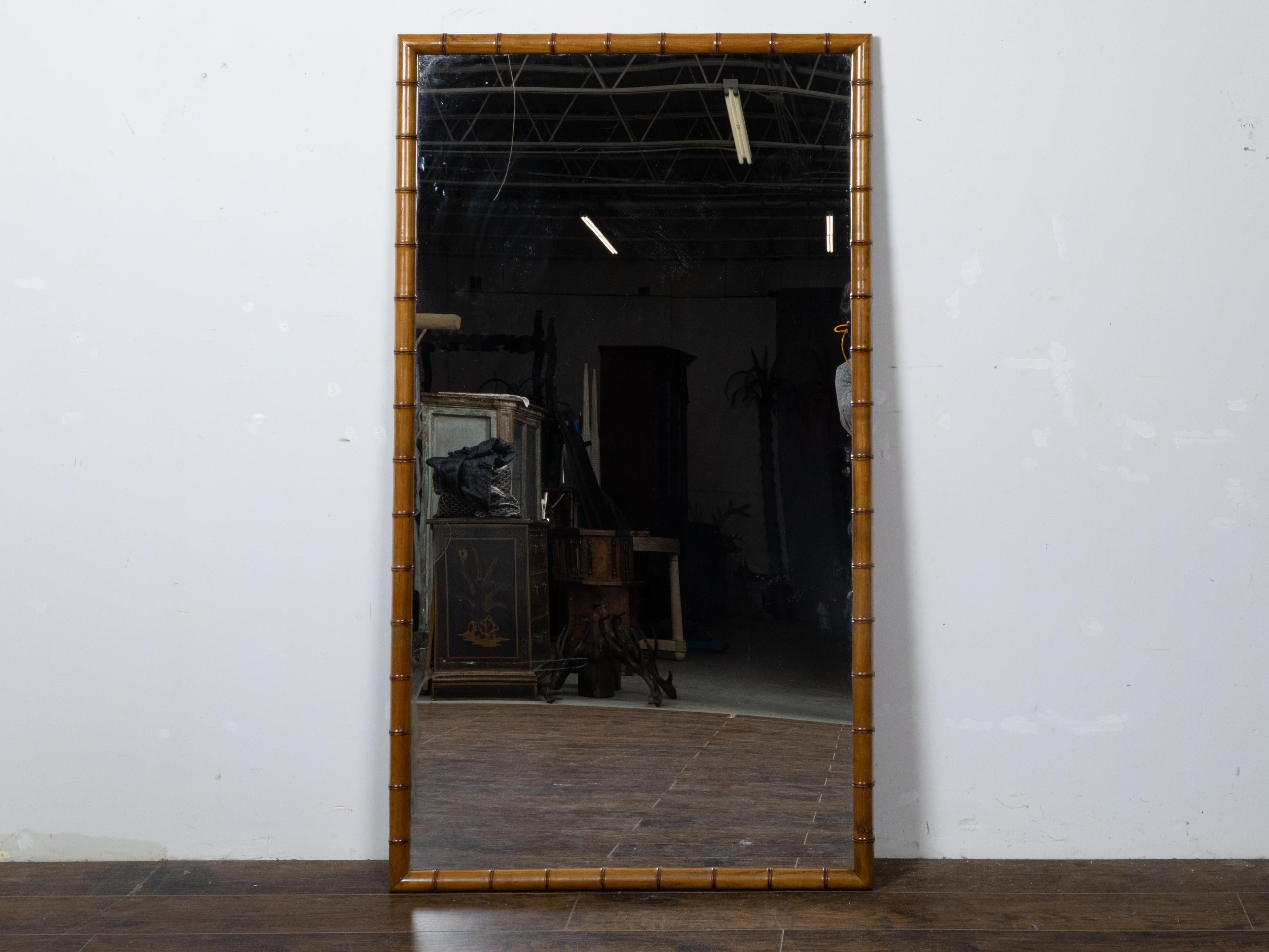 A large French Turn of the Century faux bamboo walnut mirror from circa 1900. Step into the allure of early 20th-century French design with this large faux bamboo mirror from the Turn of the Century, circa 1900, a piece that beautifully marries