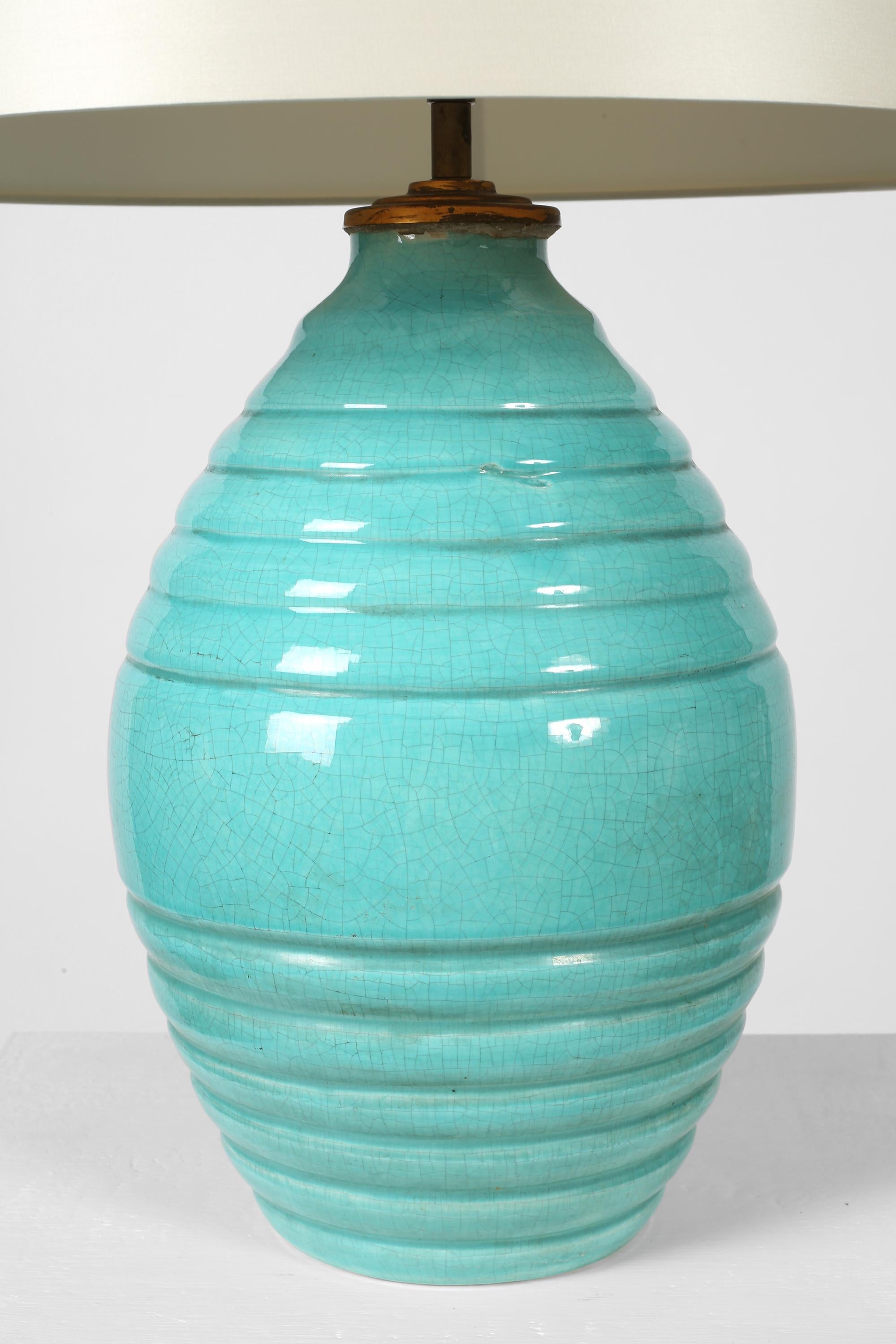 A large Art Deco ceramic table lamp with decorative incised banding and vivid, turquoise crackle glaze.

Supplied with an off-white dupion silk shade.