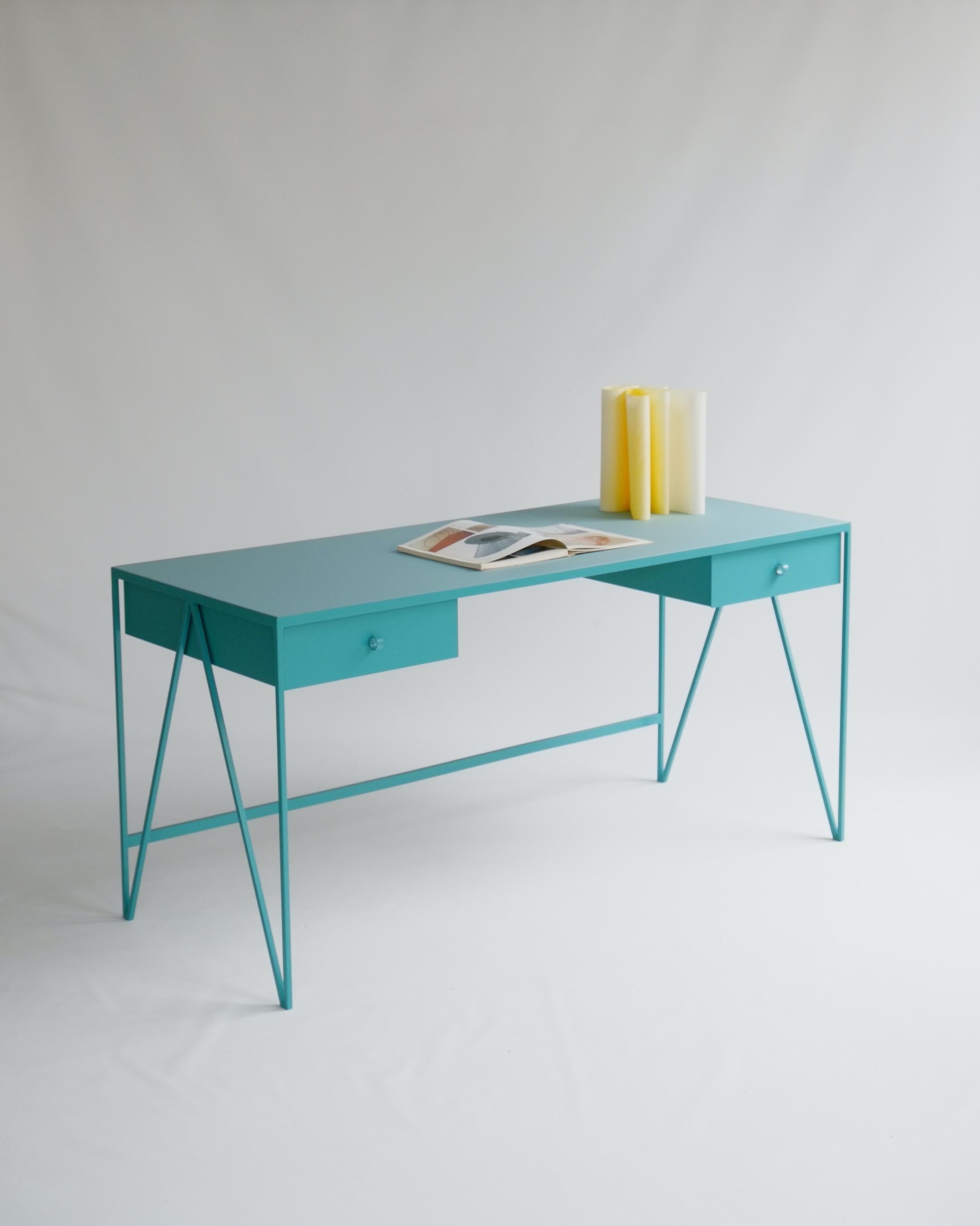 This large turquoise study desk is made with a powder coated steel frame and a beautiful natural linoleum top made out of linseed oil. This modern minimal desk has two steel drawers suspended underneath the tabletop with our Loop handles. The soft