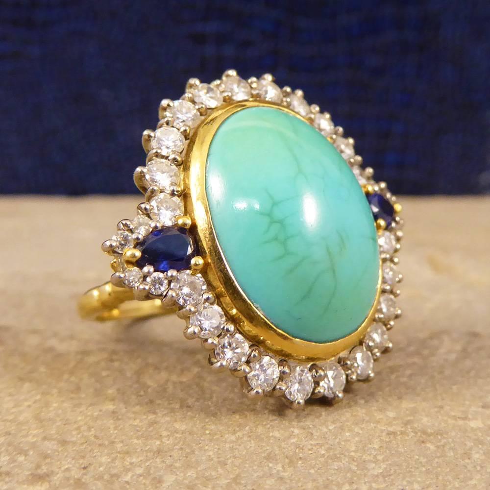 Featuring one large Turquoise stone measuring 17mm by 13mm with an 18ct yellow Gold rub over setting. With a total of 1.04ct of Diamonds surrounding the large turquoise stone with two pear shaped Sapphires on either side. Crafted from 18ct yellow