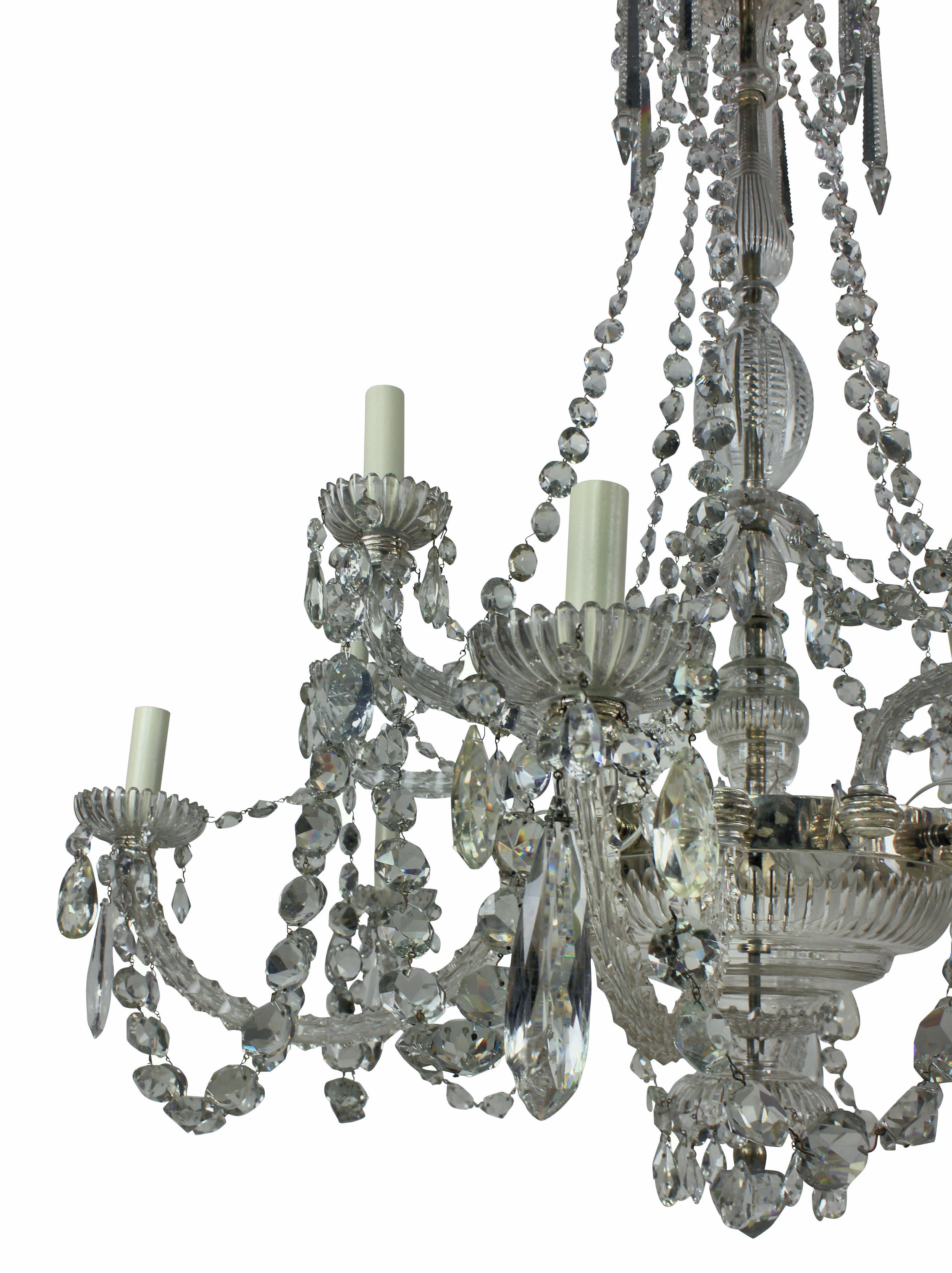 An English finely cut-glass chandelier of good quality by Perry & Co of New Bond Street. With twelve faceted scrolled branches in two tiers issuing stellar cut pans and nozzles from lobed wells and baluster vase shaped column, hung with faceted
