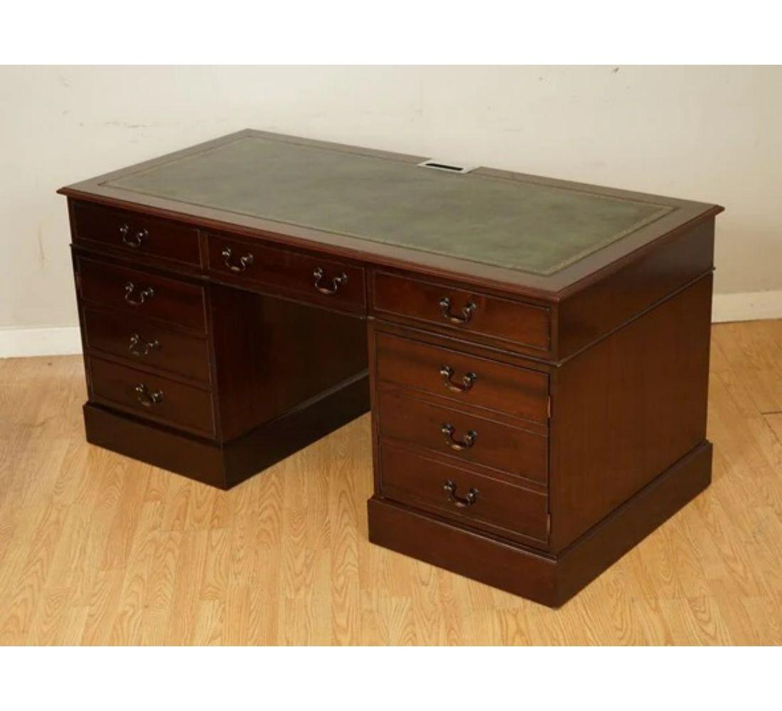 We are delighted to offer for sale this stunning hardwood twin pedestal desk.

It has a green leather inlaid top with gold embossing around it. On the top of the desk, there's a grommet to put cables through.

Behind the door, some platforms can