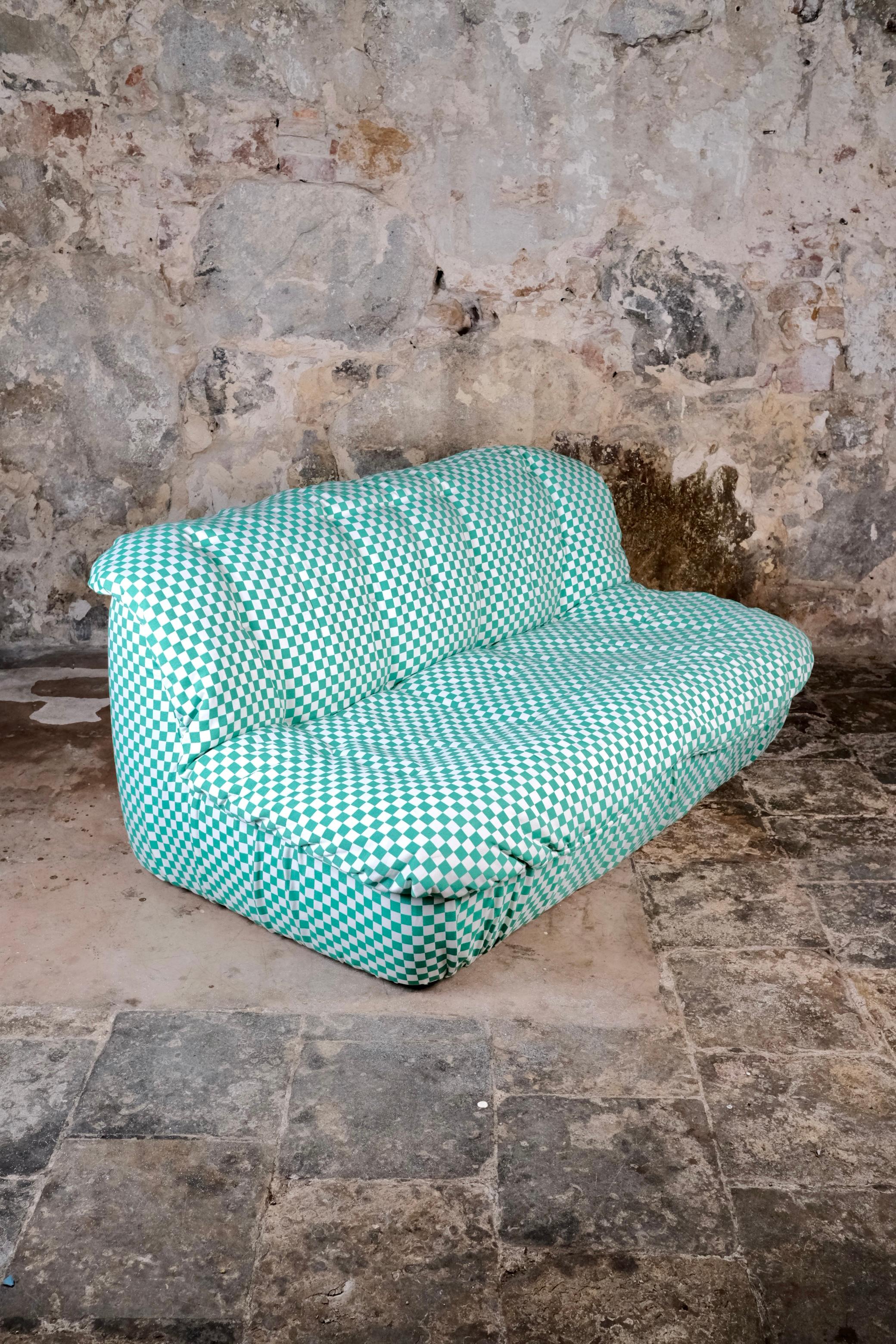 A delightful and sculptural two-seat sofa crafted in France in the 1980s, fully reupholstered in a fresh and playful checkered fabric in mint green and white. 
The sofa features generous, organic curves that invite comfort and conversation, while