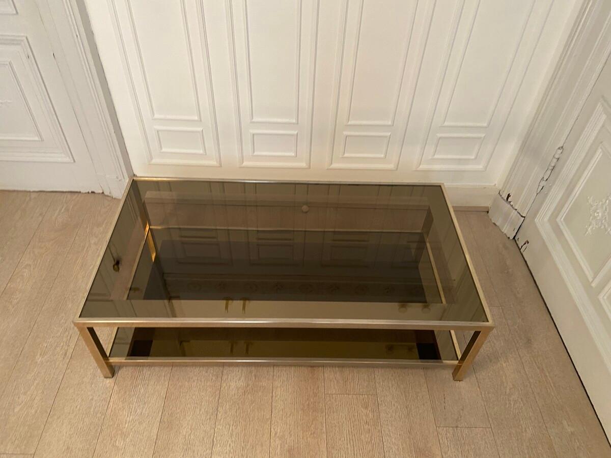 Large two-tier coffee table in the style of Romeo Rega, 1970s.
Large two-tier coffee table in the style of Romeo Rega, 1970s. The metal structure covered with brass, offers two transparent glass tops, one of the two of which is bevelled and