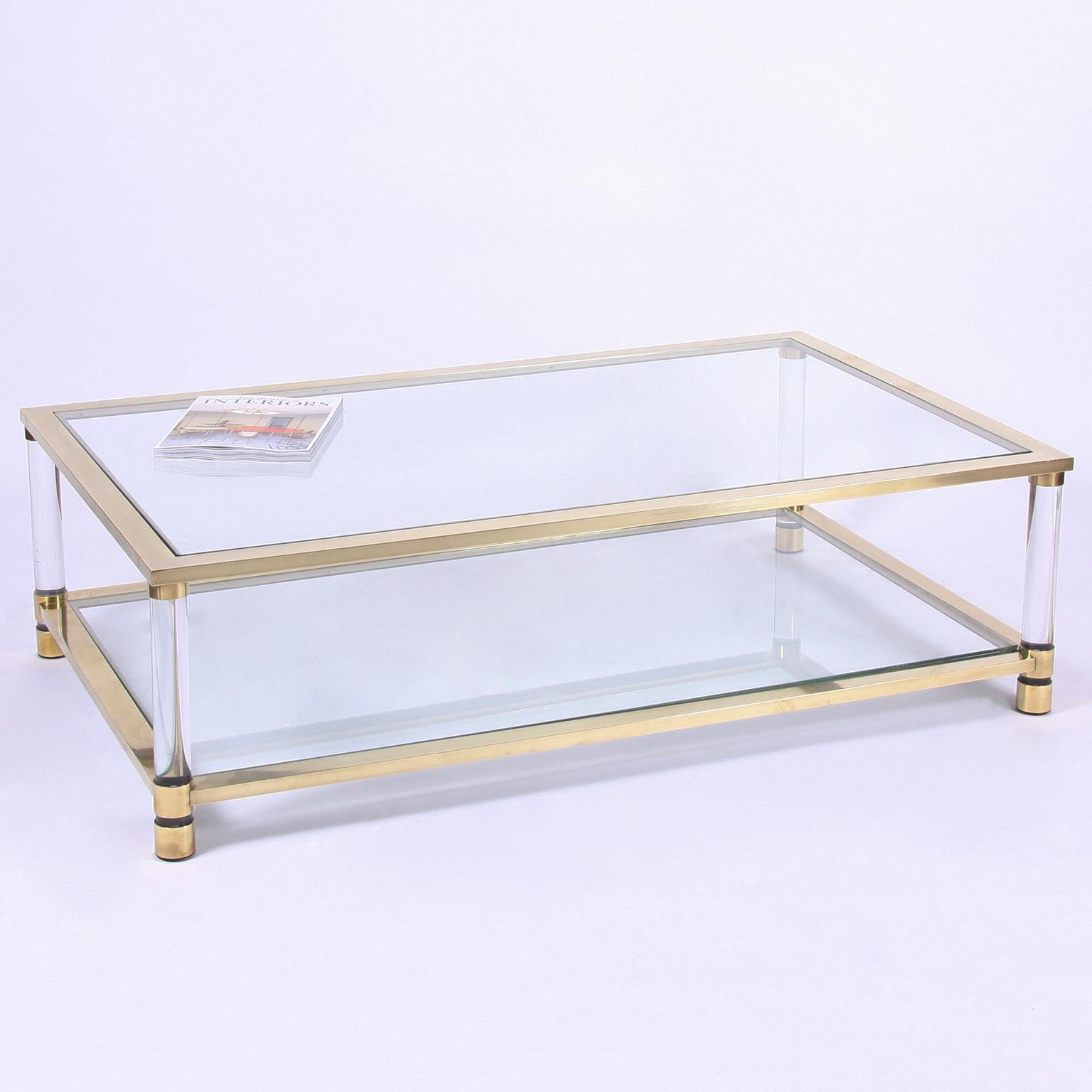 French, circa 1970

A chic, two-tier, large coffee table. This stunning, glass and brass model, also has Lucite legs.