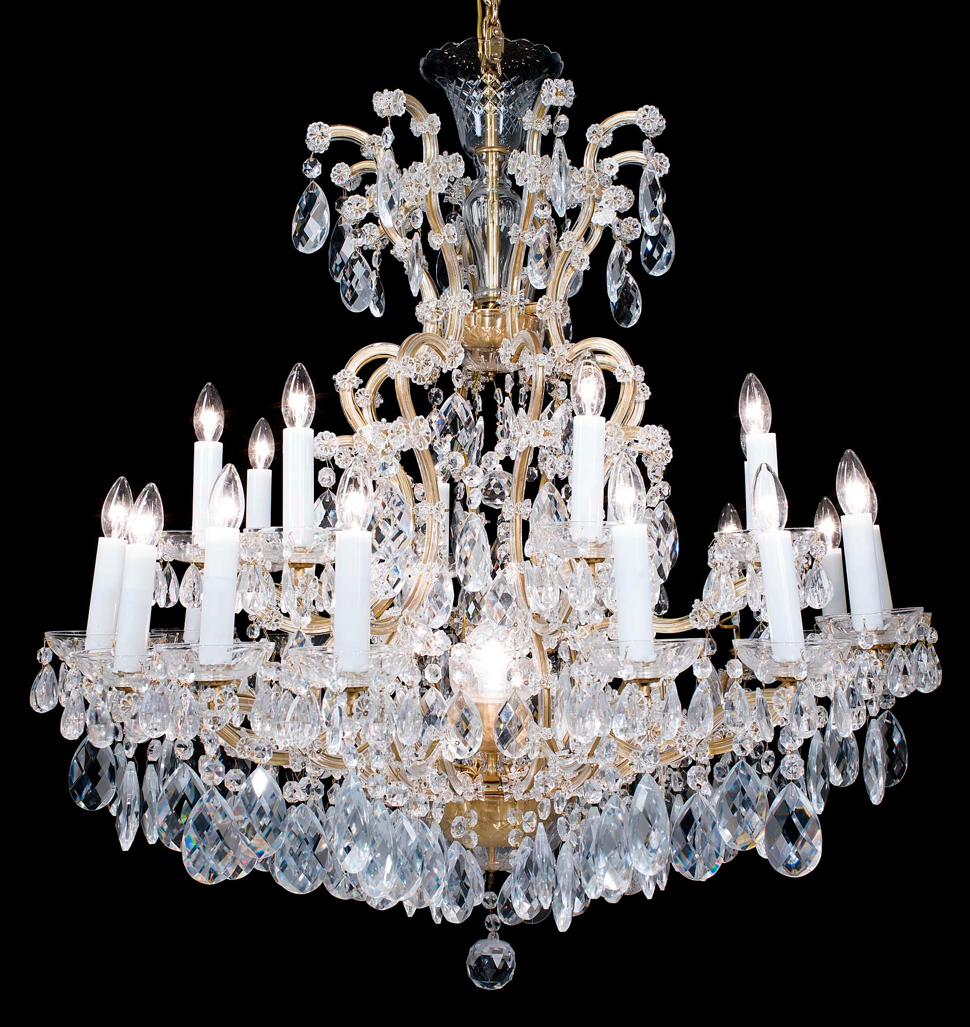 A large two-tier, twenty four light glass and brass 20th century chandelier in the neoclassical style. The upper tier has eight brass scrolling branches the lower with sixteen, all enhanced with multiple florets, issuing from an ornate brass bowl