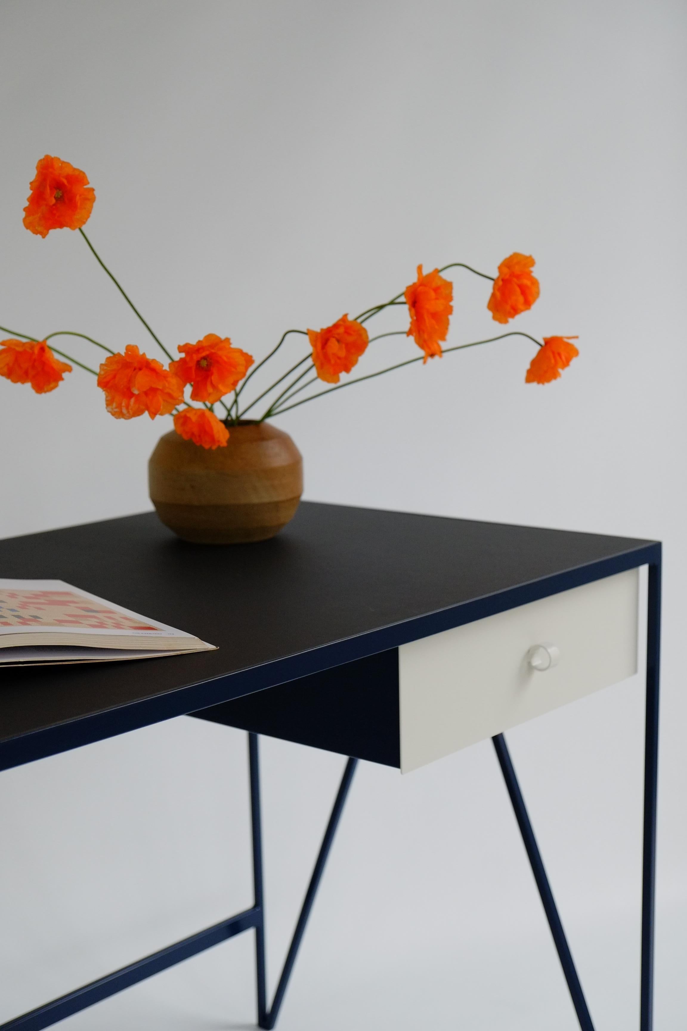 This large two-tone study desk is made with a powder-coated steel frame and a beautiful natural linoleum top made out of linseed oil. This modern minimal desk has two steel drawers suspended underneath the tabletop with our Loop handles. This desk