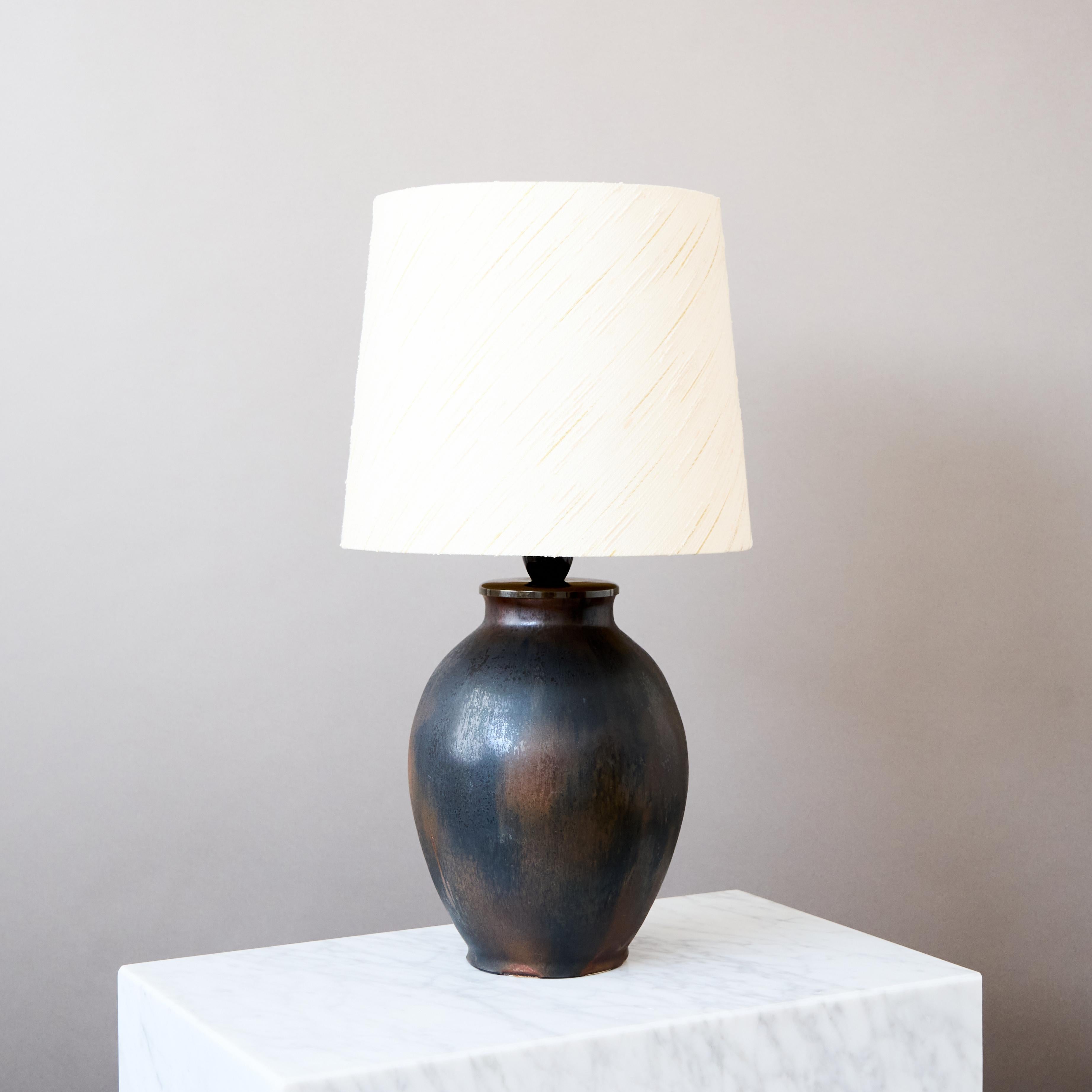 Elegante e unica lampada da tavolo in gres con un'eccezionale smaltatura marrone scuro e nera. 
La lampada è stata realizzata da Lotte Lindahl presso Bing & Grondahl, Copenaghen, Danimarca, negli anni Trenta.

Ottime condizioni originali, senza