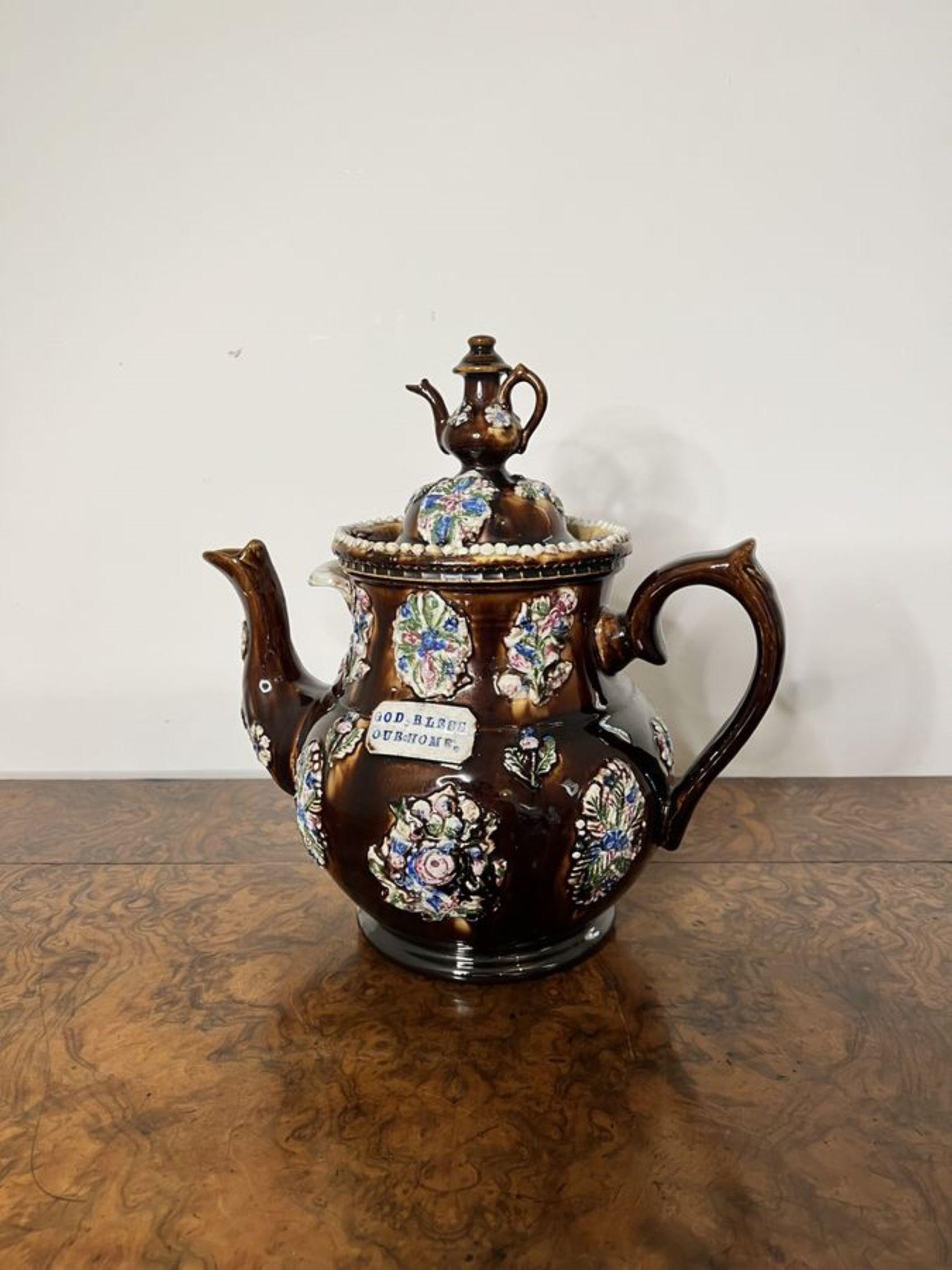 Large unusual antique bargeware tea pot with 'GOD BLESS OUR HOME' inscribed on a brown bargeware teapot decorated with wonderful bunches of flowers in blue, green, pink and white colours, the lid having a small teapot finial to the top with a shaped