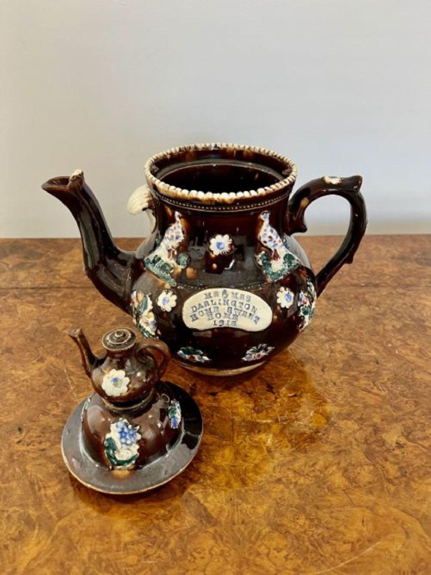 Large unusual antique tea pot with 'Mr & Mrs Darlington home sweet home 1915' inscribed on a brown teapot decorated in wonderful birds and flowers in blue, green, white, yellow and red colours, the lid having a small teapot with a shaped handle and
