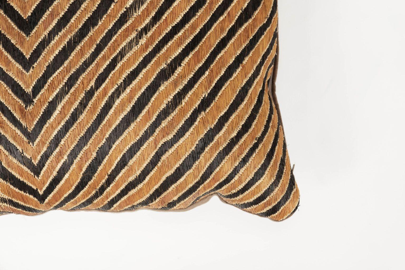 Large unusual custom cushion from vintage African Kuba cloth cushion. Hand-dyed ebony and orange color raphia palm woven in a bold pattern. Backed with brown linen. Includes zip fastener and feather insert.