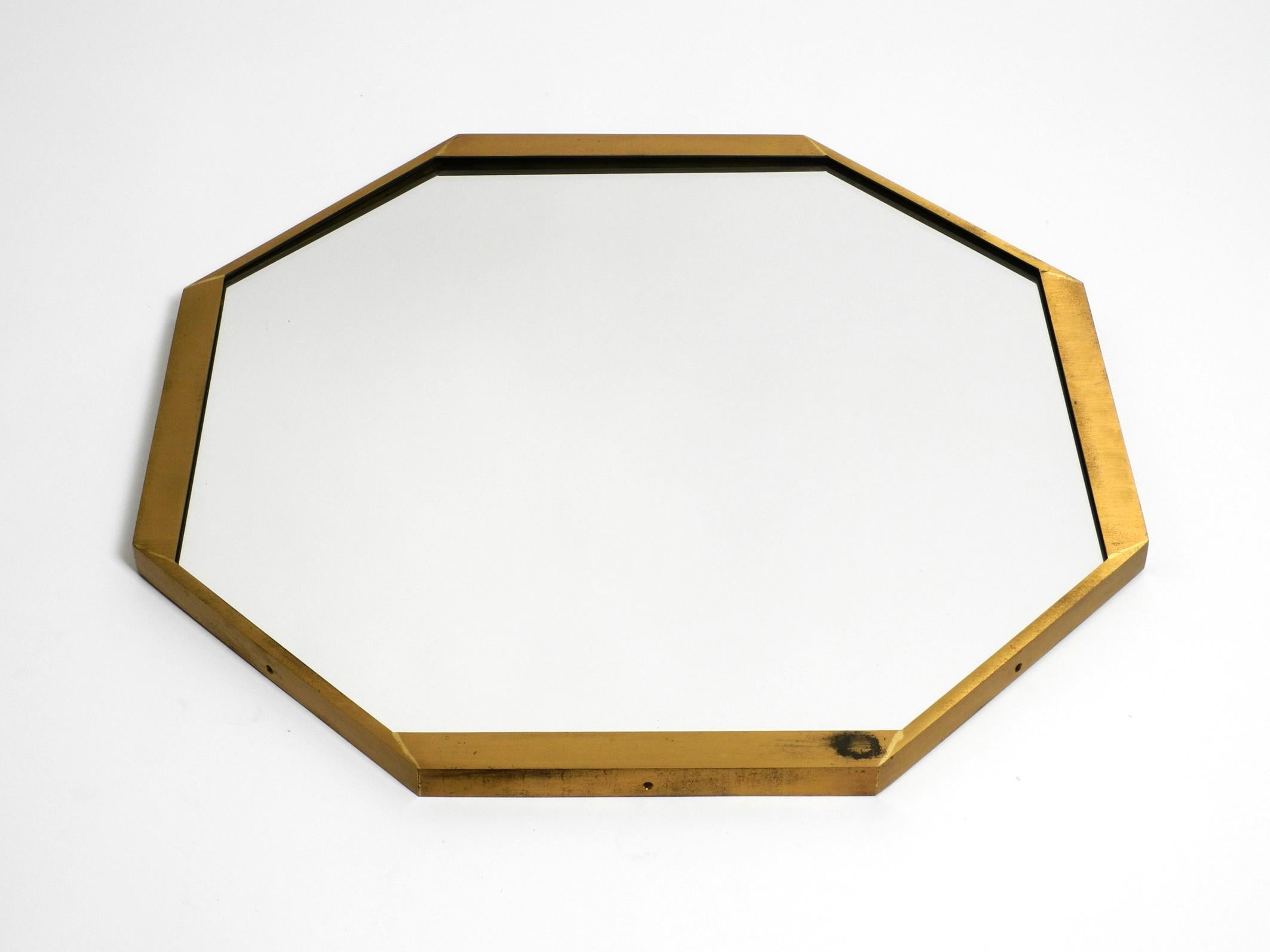 Grande specchio da parete ottagonale in ottone del Mid Century, pesante e insolito.
Design di alta qualità. Prodotto in Italia.
In ottime condizioni, senza danni al vetro dello specchio e alla cornice. Non è cieco. Non ci sono urti o ammaccature sul