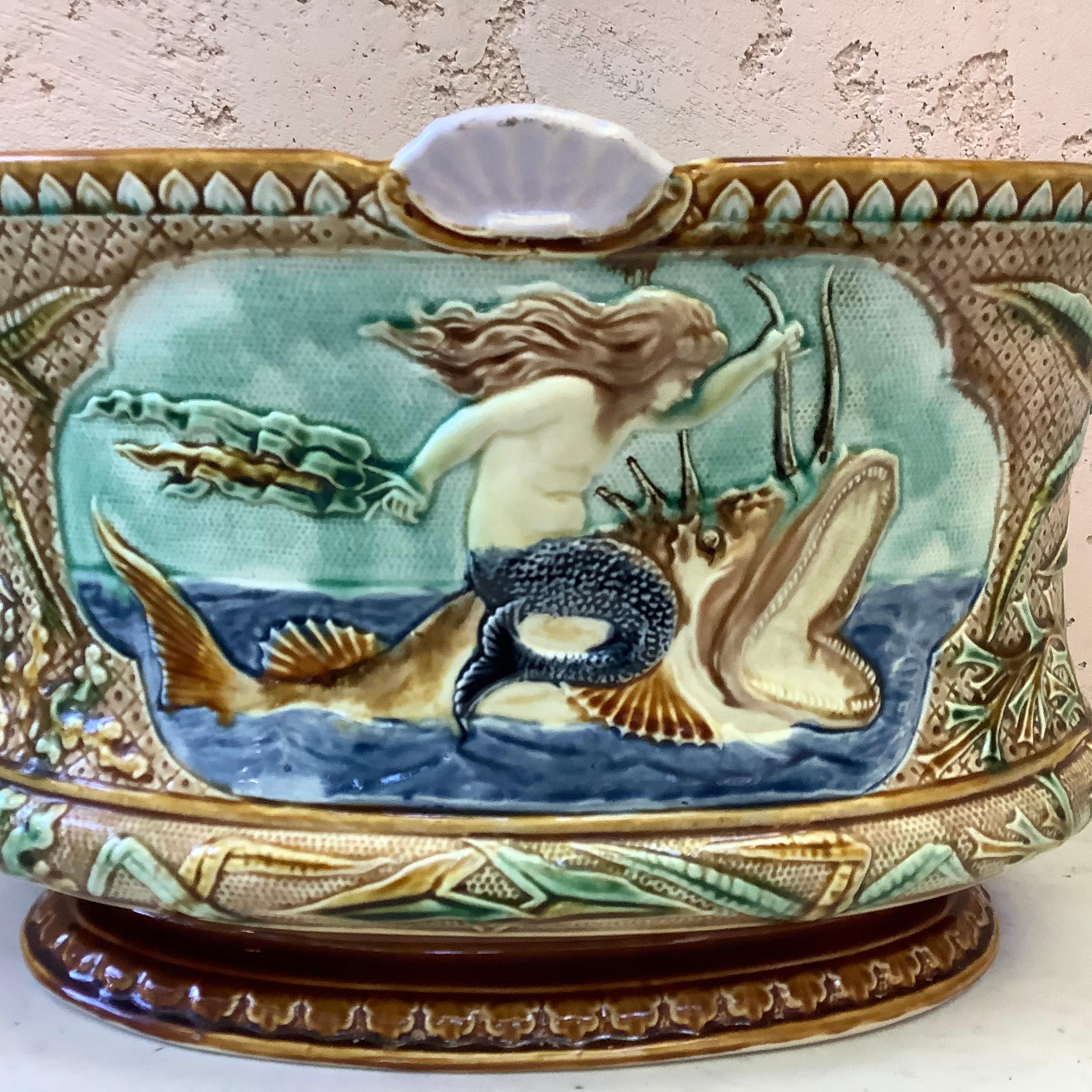 Large unusual Majolica mermaid jardinière, circa 1880.
A mermaid on the top of a large fish with shells and seaweeds.