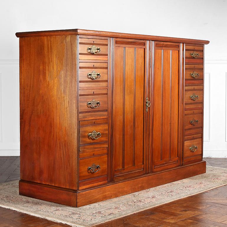 A large 19th century Scottish, mahogany linen press, composed of two flights of five drawers flanking two panelled doors that open to four, wide, pull-out linen drawers providing comprehensive storage space.