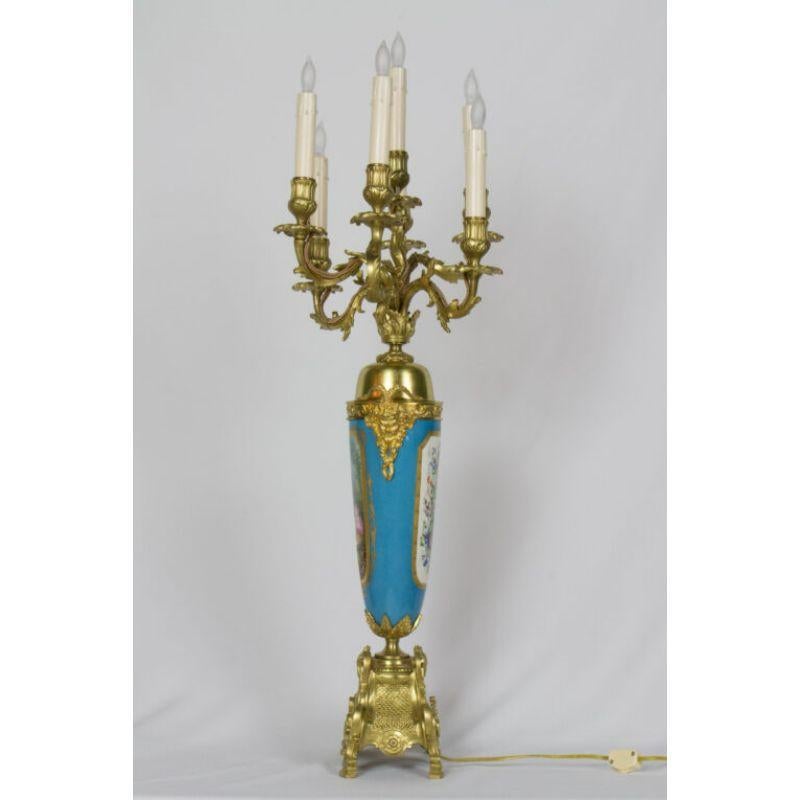Large urn form French gilt bronze and turquoise porcelain candelabra. Inspired by the designs of Sevres Porcelain. On one side there is a design of flowers and the other of a pastoral scene with a boy and a girl. Seven Lights. Rococo style.