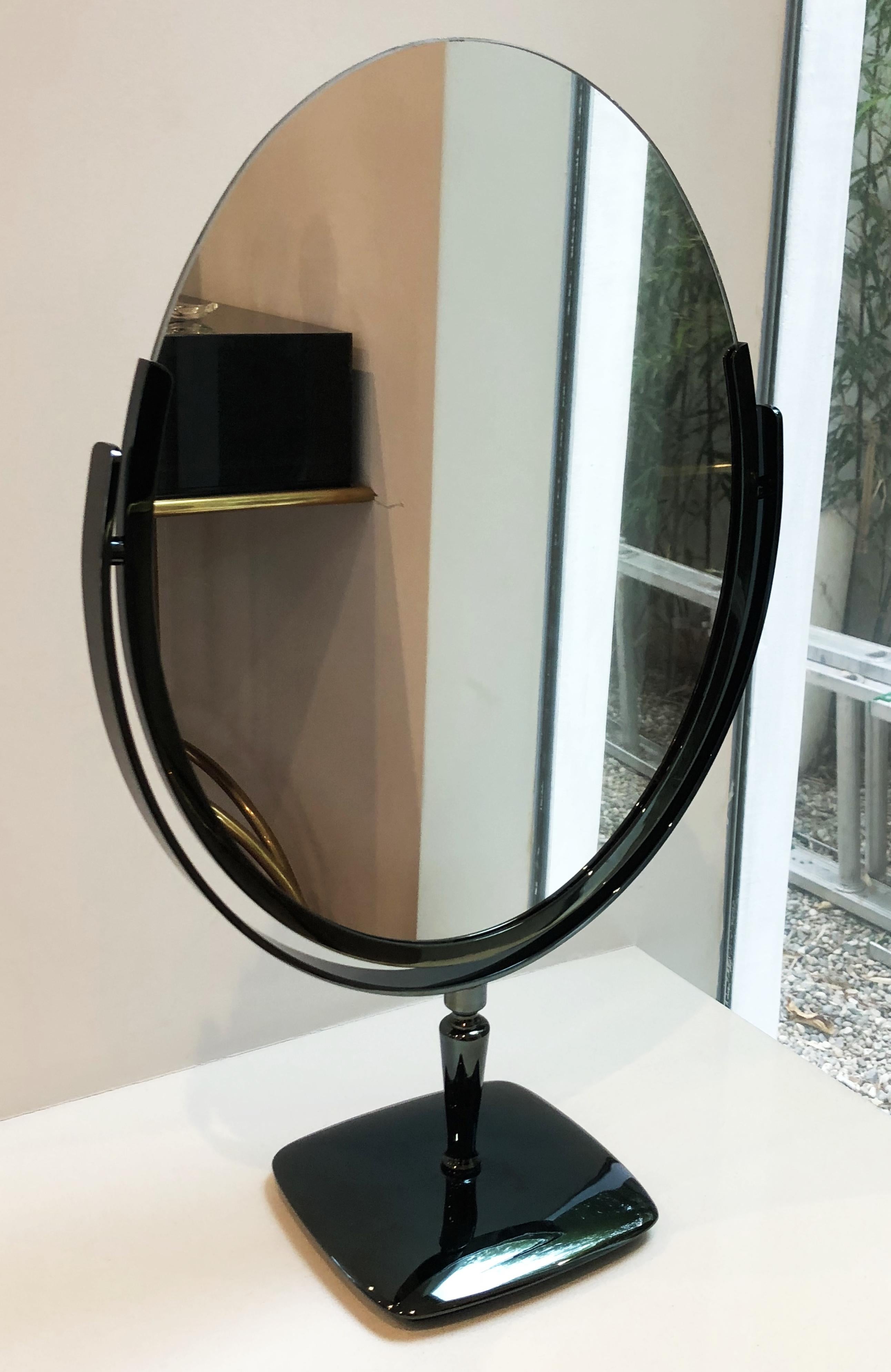 Large and beautiful oval mirror designed and manufactured by Charles Hollis Jones in the 1960s.
The mirror has a beautiful black nickel finished frame and base, the mirror is double sided and it can be flipped to be used on either