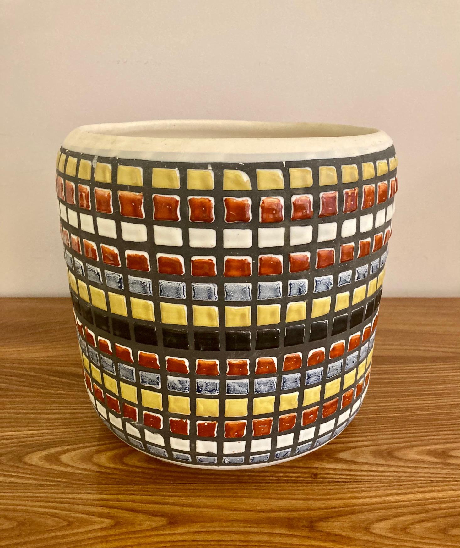 A large cylindrical vase, cachepot or wine cooler,
Glazed ceramic with blue, red, yellow, blackened and white geometrical pattern.
This decor is referred to as 