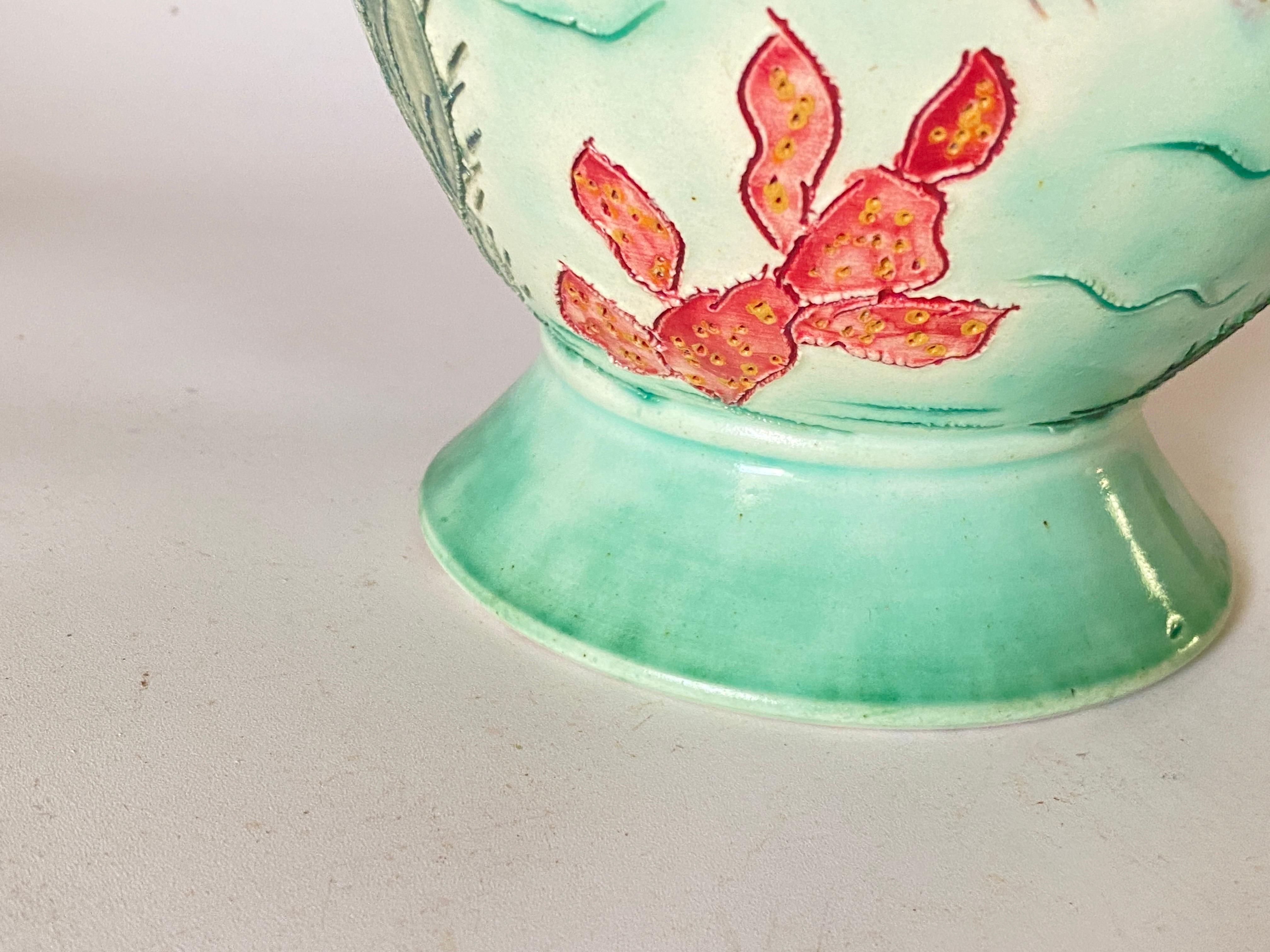 It is a ceramic vase, which has been painted by hand. It is signed by the artist, and dated circa 1970. This vase was made in Vallauris in France. The dominant colors are red and green.