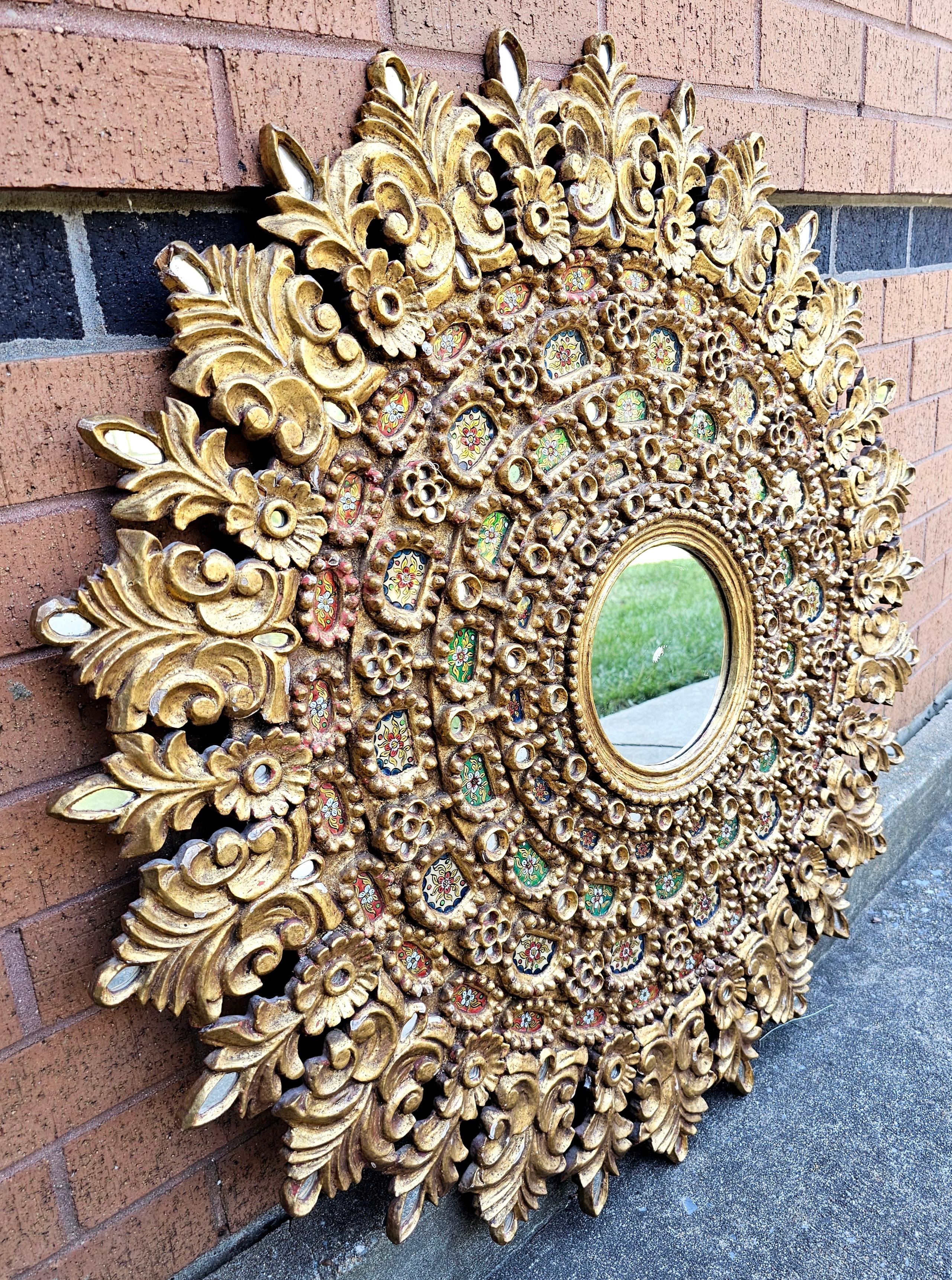 Grand miroir mural rond en bois doré de style colonial espagnol, décoré de paillettes de différentes couleurs par l'artiste Velasquez. Le cadre doré est sculpté dans du bois massif. 
 Des fleurs de lys et d'autres fleurs apparaissent dans les coins