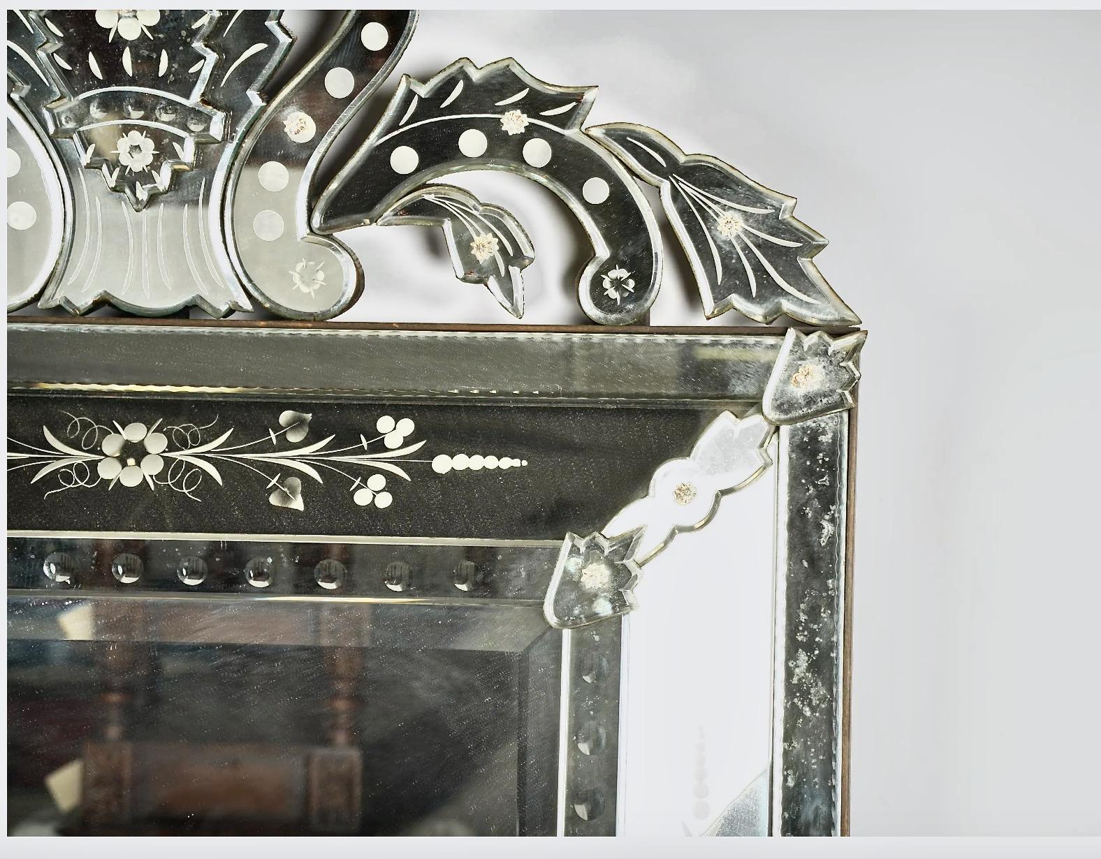 This is a large impressive Venetian mirror that dates to c. 1950-1960. The frame consists of multiple etched and carved mirrored elements and is in overall very good condition.