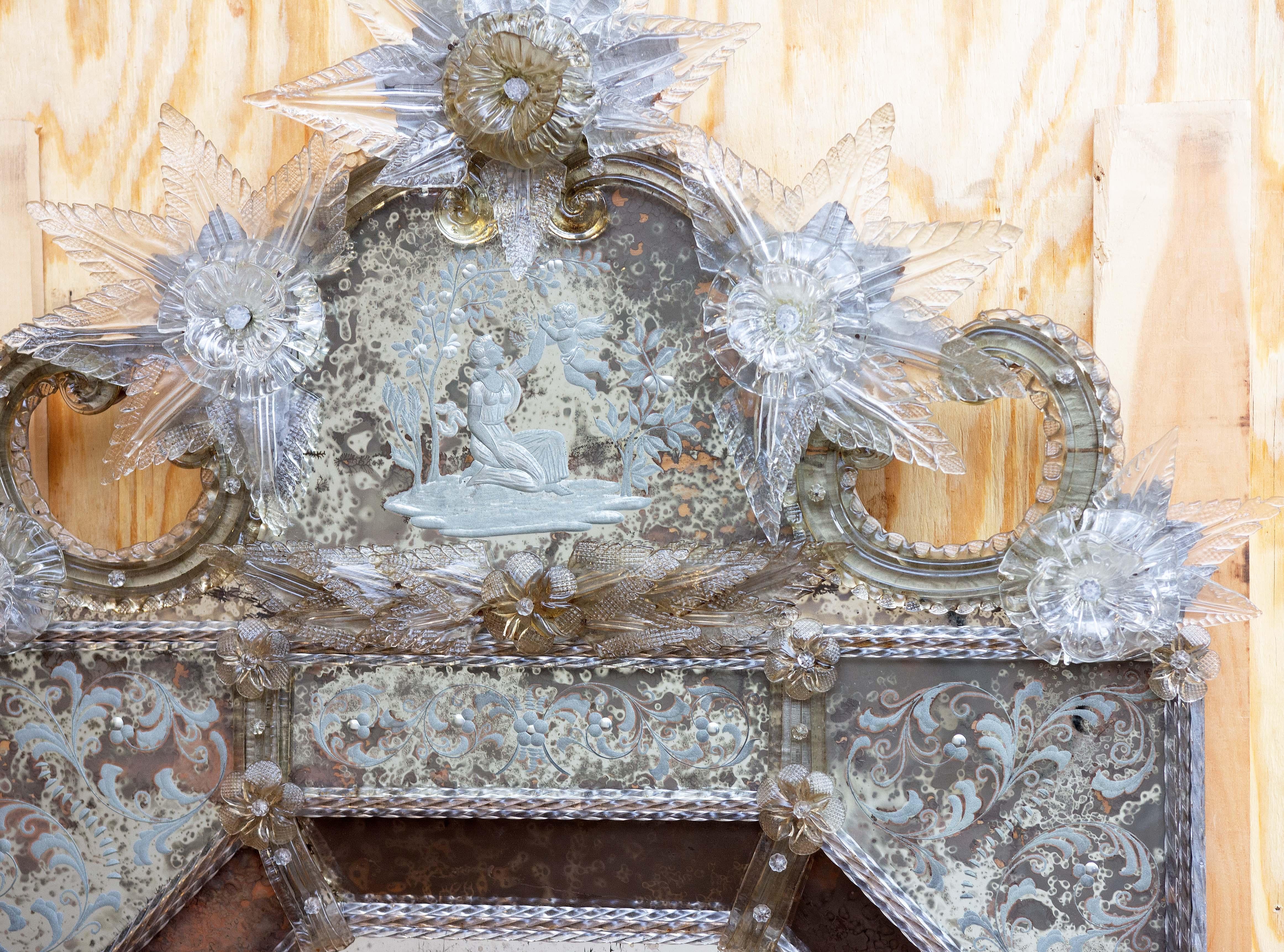 Miroir vénitien en verre de Murano du début du 20e siècle. Verre soufflé à la main avec panneaux gravés. Belle patine sur le verre du miroir. 


    