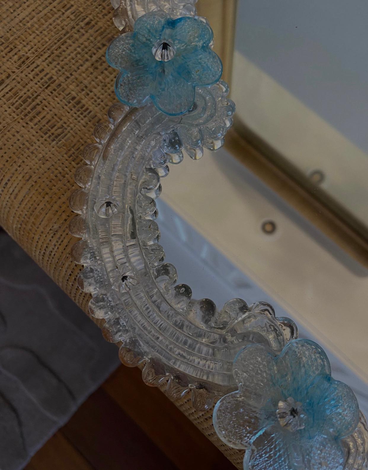 Beautiful midcentury murano mirror with blue murano flowers. This piece has a hook on the back for hanging purposes. 