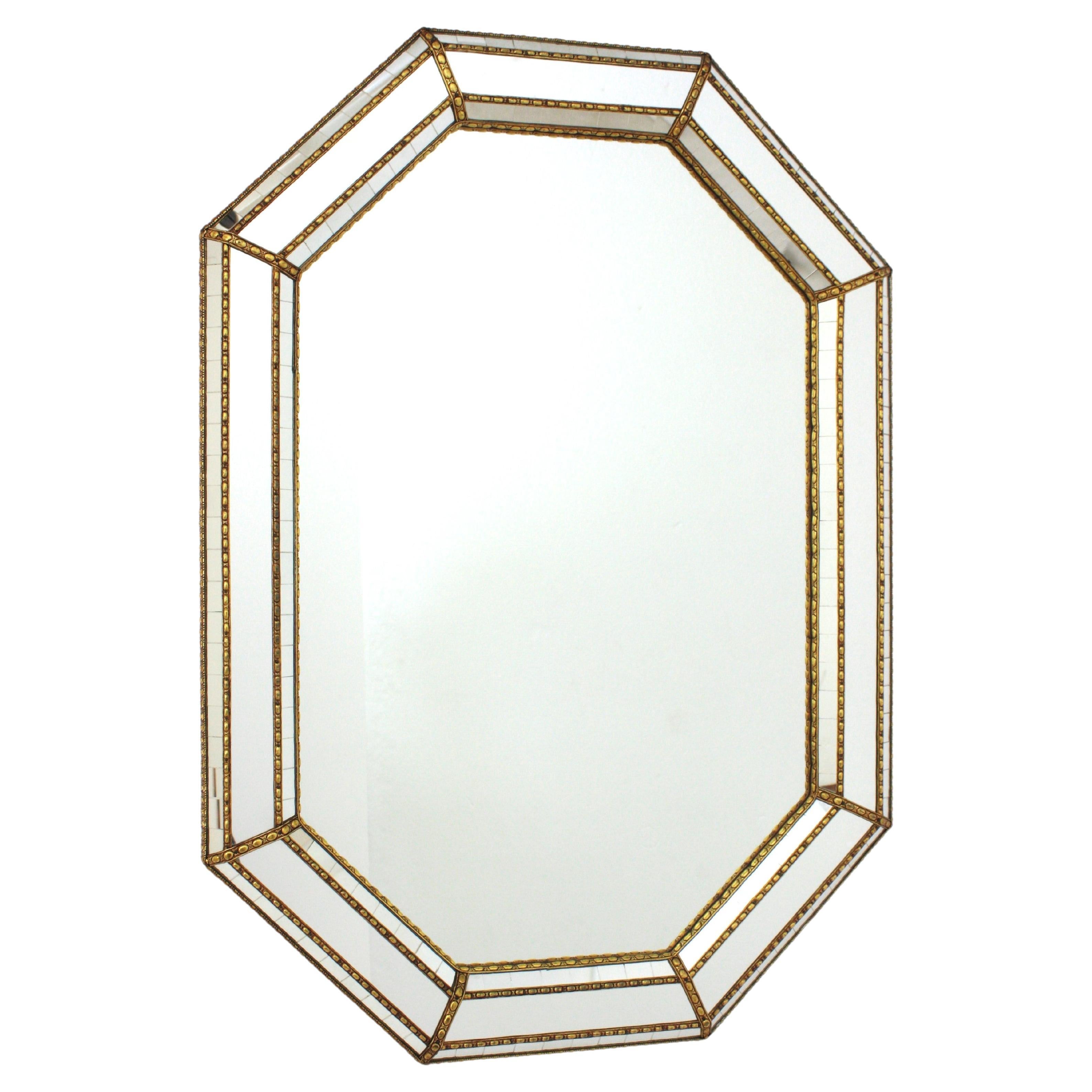 Miroir mural octogonal moderne vénitien avec cadre en laiton
Miroir mural octogonal de style vénitien avec accents en métal doré, Espagne, années 1960
Ce miroir octogonal est doté d'un triple cadre. Deux niveaux de petits morceaux de miroir en