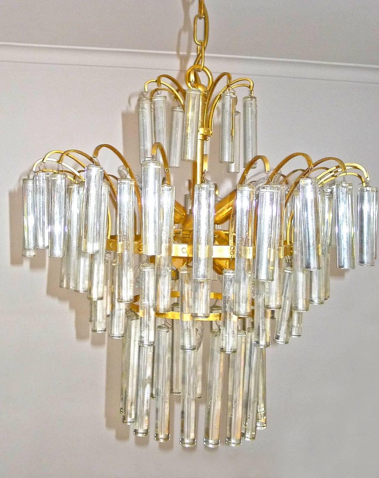 Large and heavy crystal waterfall wedding cake chandelier with eight-light flush mount chandelier, attributed to Venini. This piece is gold-plated and detailed with four layers of 94 solid clear crystal rods / ice sticks of two