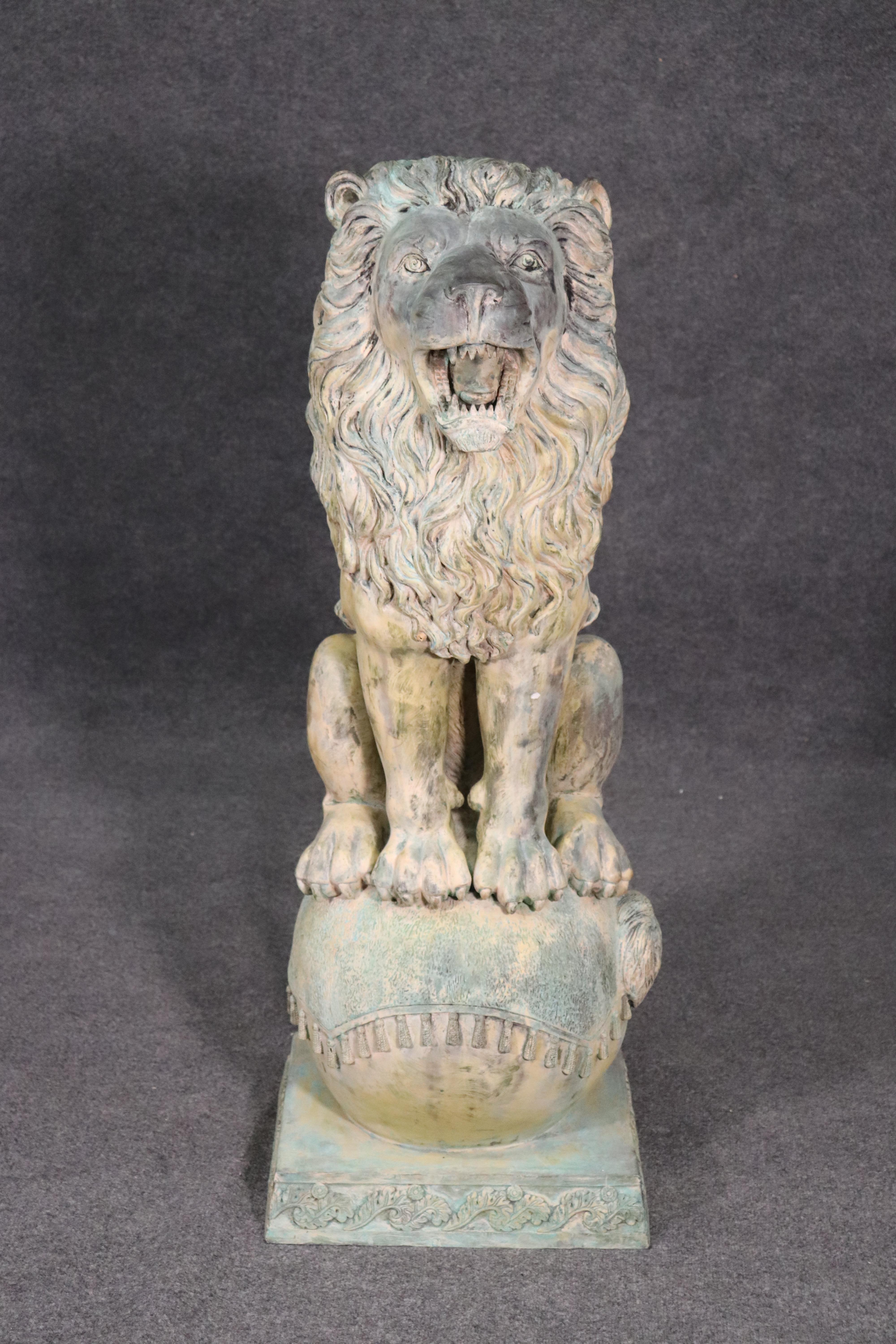 This is a very realistic standing lion bronze lion, circa 1920. The lion stands with his mouth agape and atop a decorated ball. He will protect your home or garden with pride. The lion measures 49 tall x 18 wide x 19 deep.
