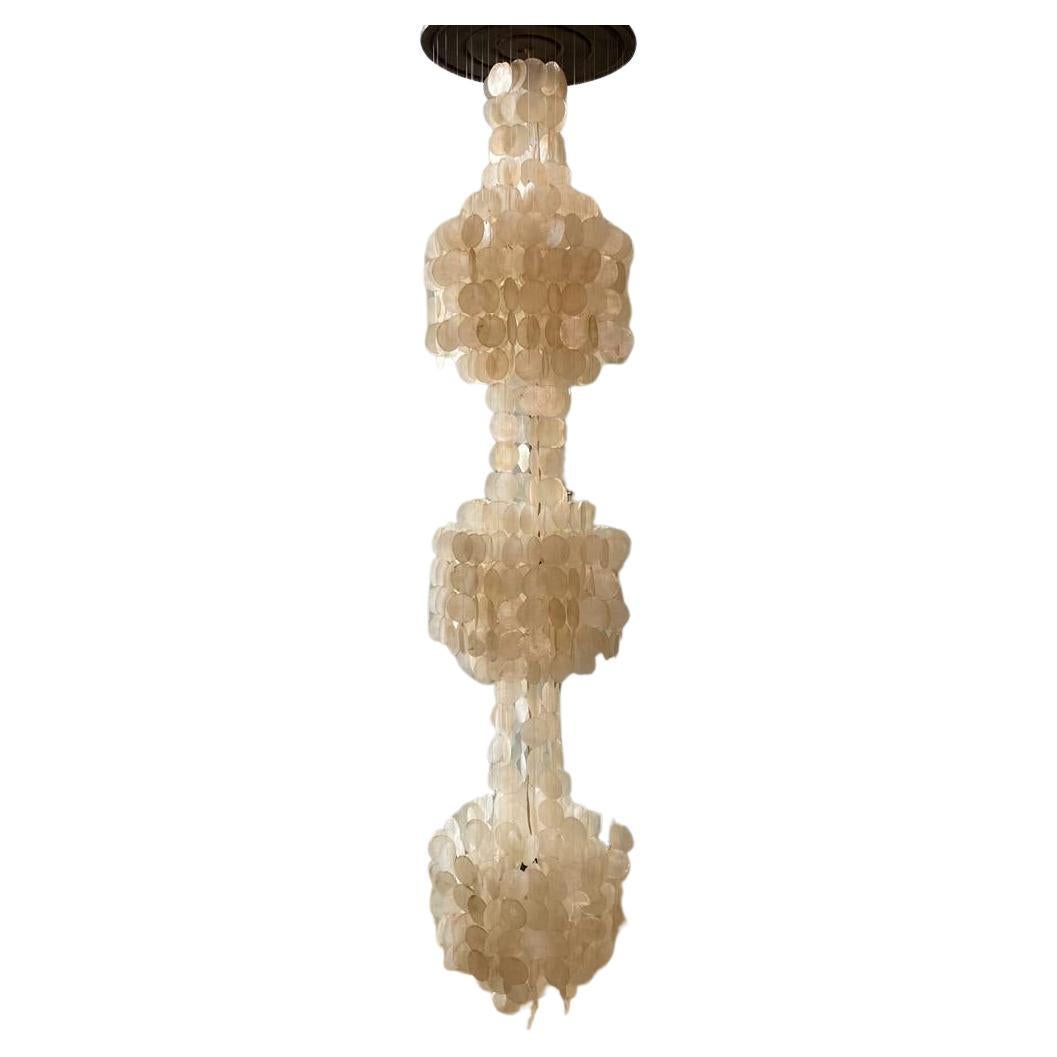 Spectacular three tier capiz shell chandelier, reminiscent of Panton’s 1964 ‘3DM’ design, is made circa 1965.
The circular capiz shell discs are mounted on a wooden ceiling plate by nylon thread connecting the shells to the top circular wood mount.