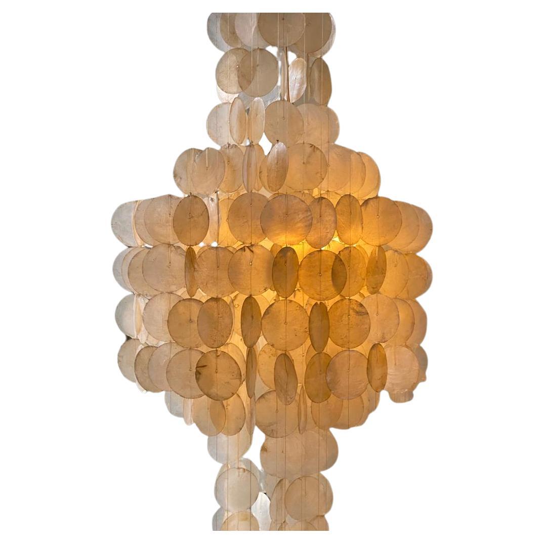 Spectacular three tier capiz shell chandelier, reminiscent of Panton’s 1964 ‘3DM’ design, is made circa 1965.
The circular capiz shell discs are mounted on a wooden ceiling plate by nylon thread connecting the shells to the top circular wood mount.
