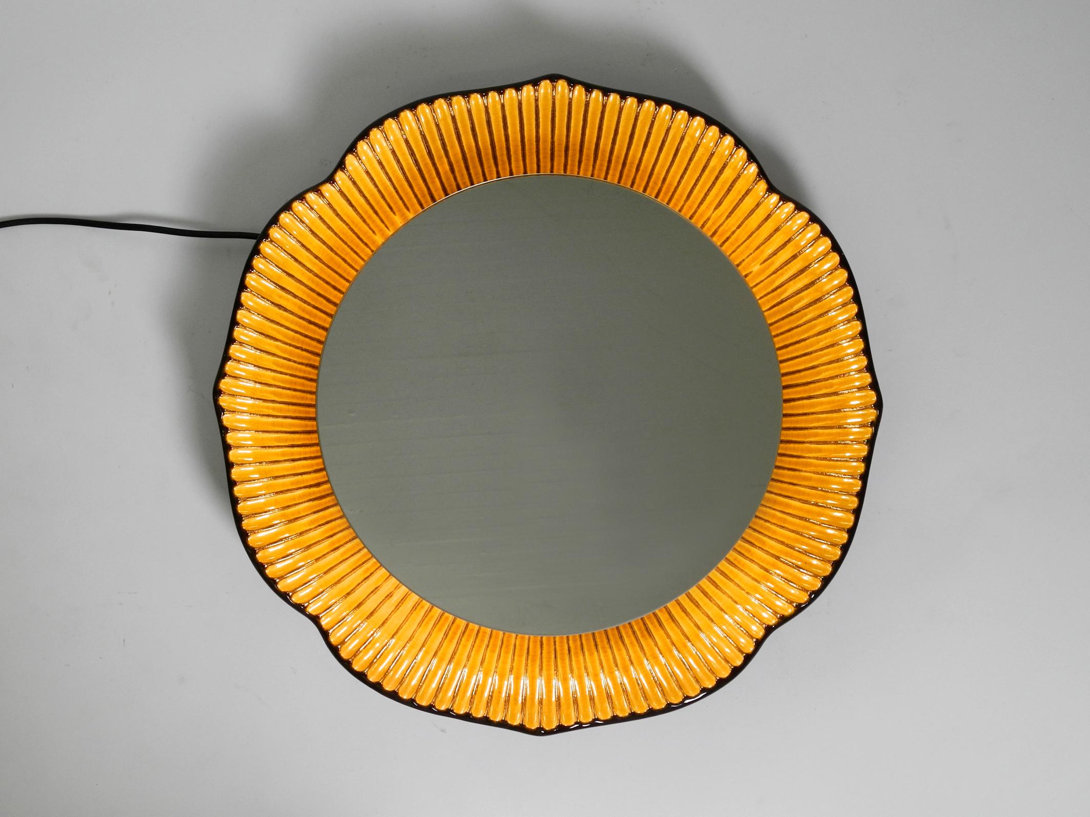 Large very beautiful illuminated ceramic wall mirror.
Extraordinary design made of ceramic coloured in brown and mustard-yellow.
Manufactured in the 1970s.
Very elaborately processed with many beautiful details. Minimalist design. Made in